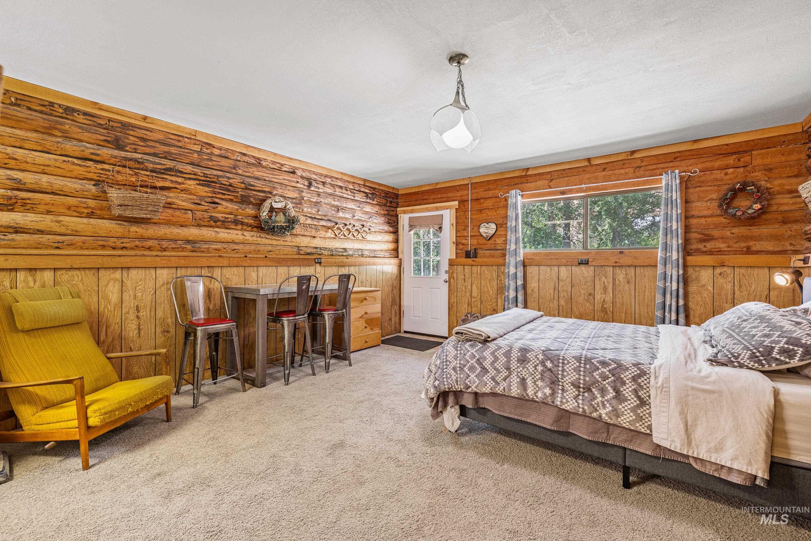 Bedroom featuring carpet and wood walls