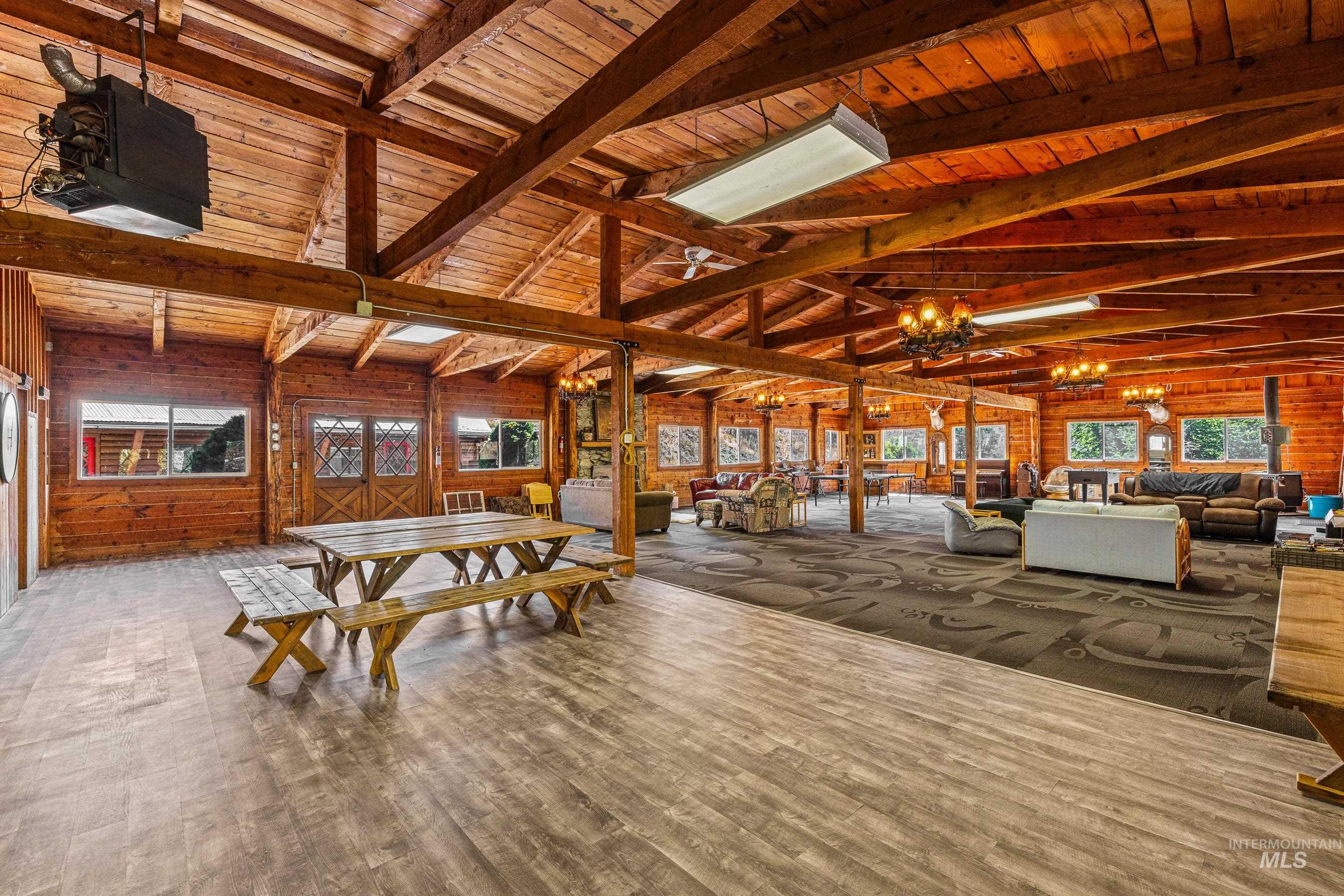 Dining space with wood walls, a chandelier, wood finished floors, and wooden ceiling