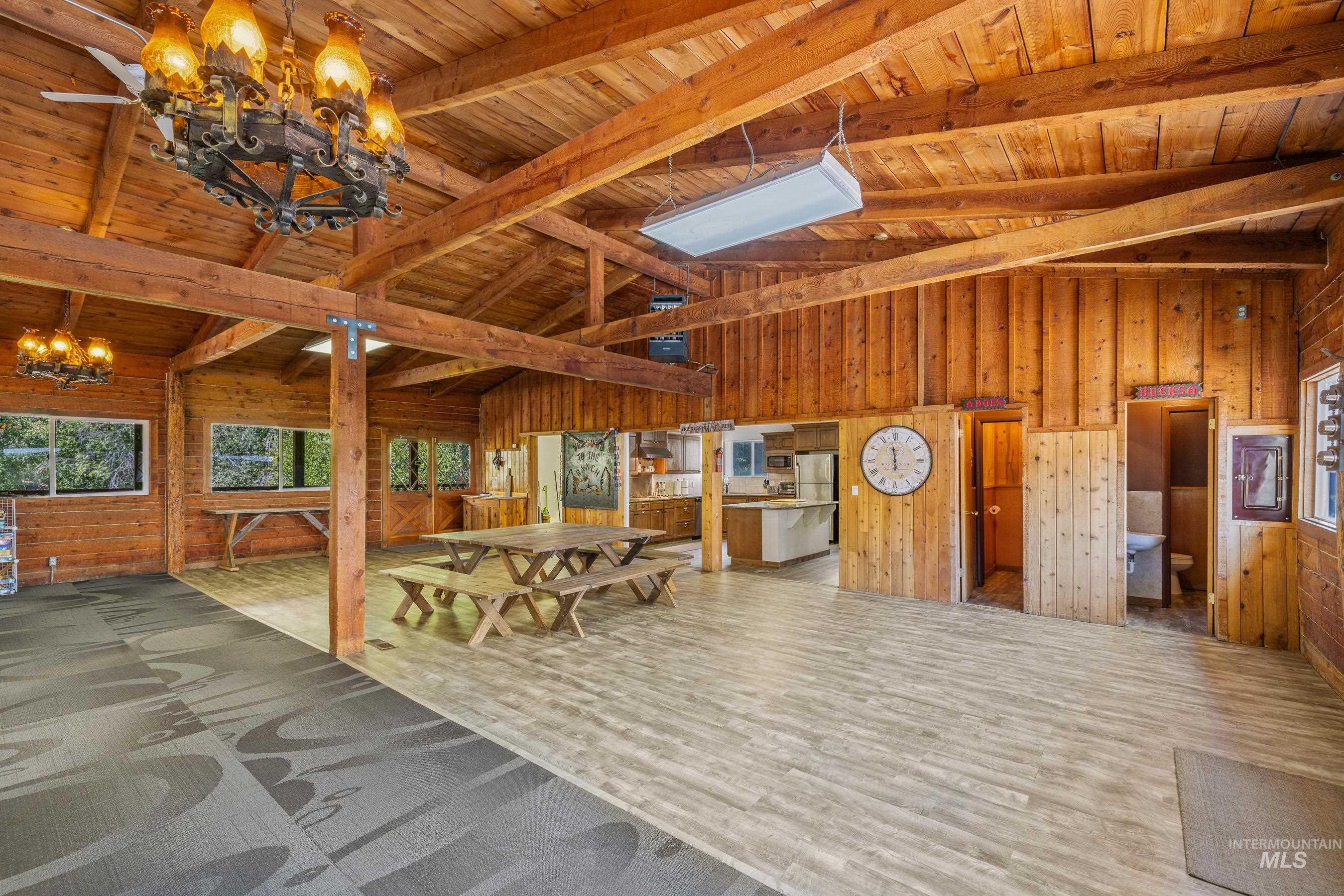 Lobby featuring wooden walls, a wood ceiling with exposed beams, and high vaulted ceiling