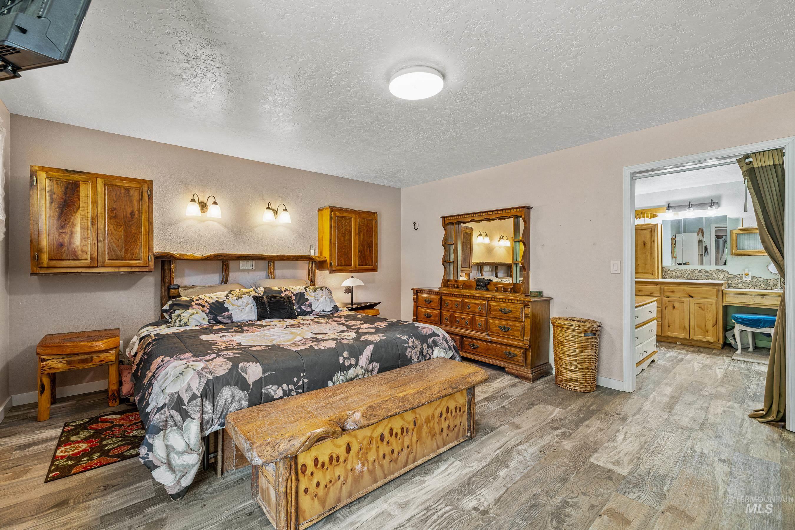 Bedroom with a textured ceiling and light wood finished floors