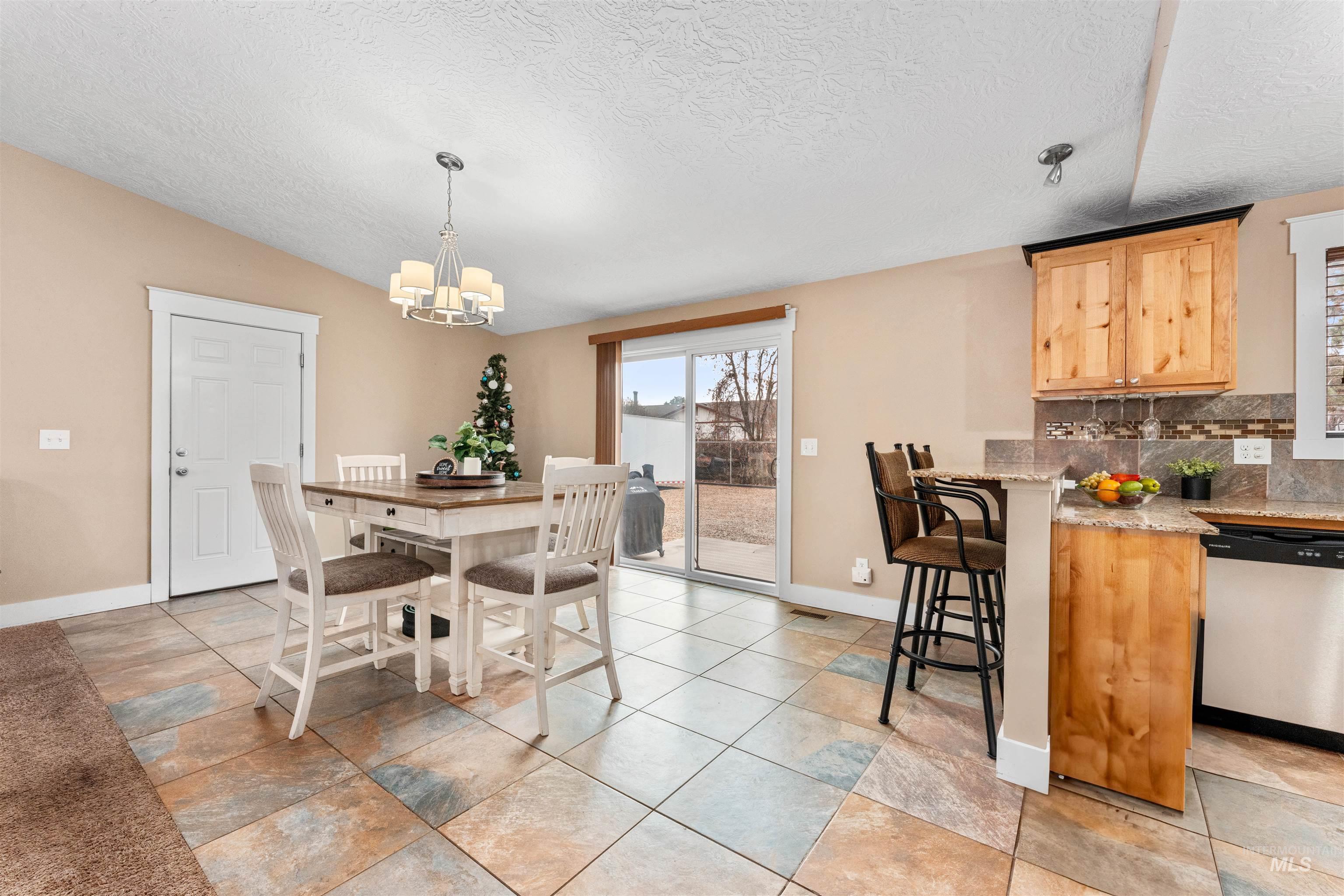 Dining area featuring a textured ceiling and a chandelier