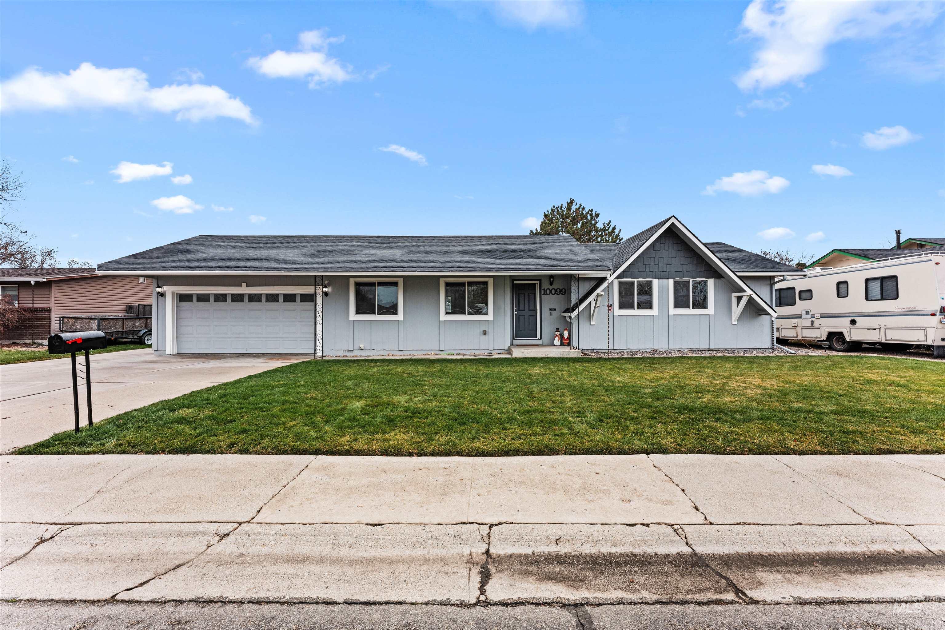 View of front of home with covered porch, board and batten siding, a front lawn, driveway, and roof with shingles