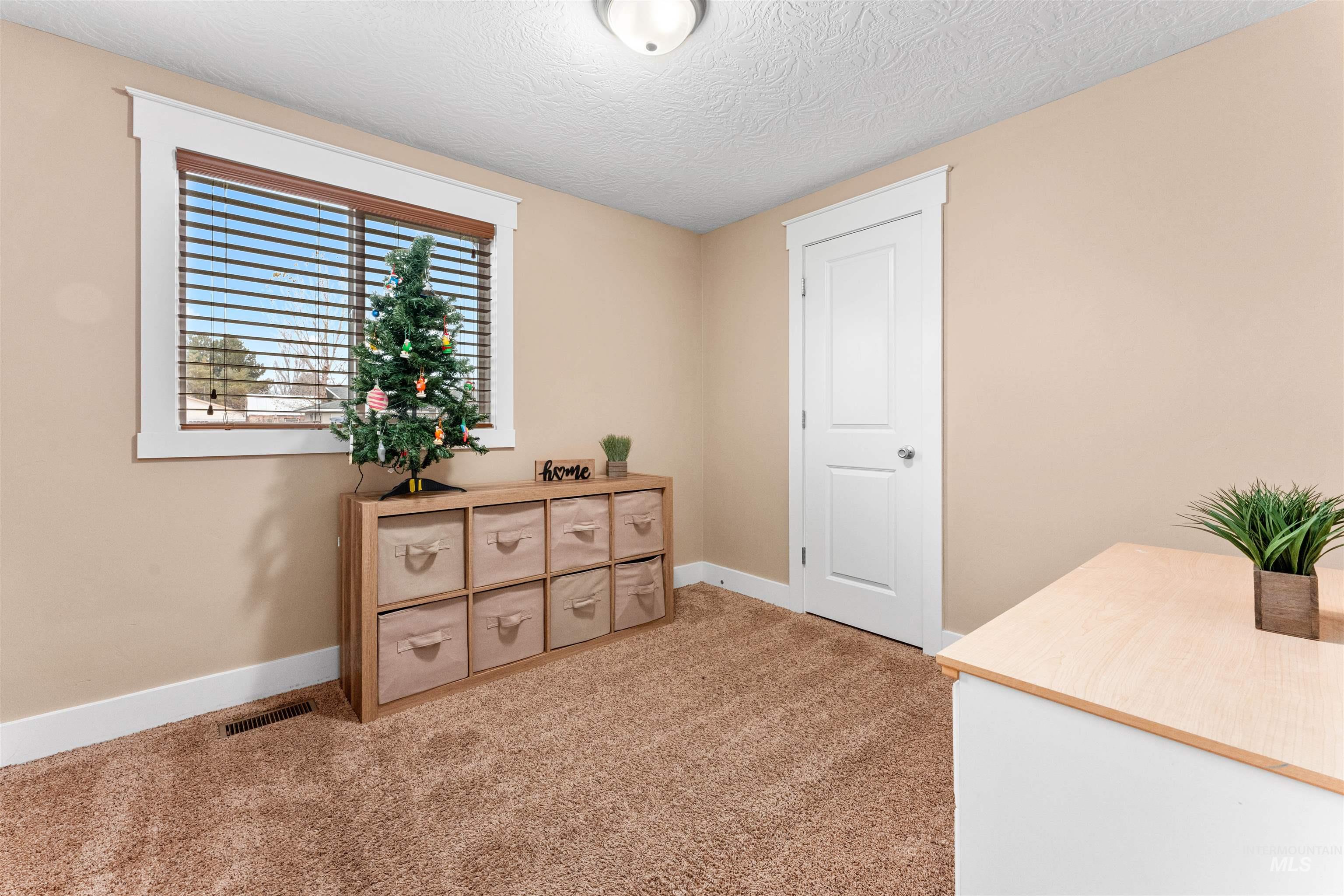 Interior space featuring light colored carpet and a textured ceiling