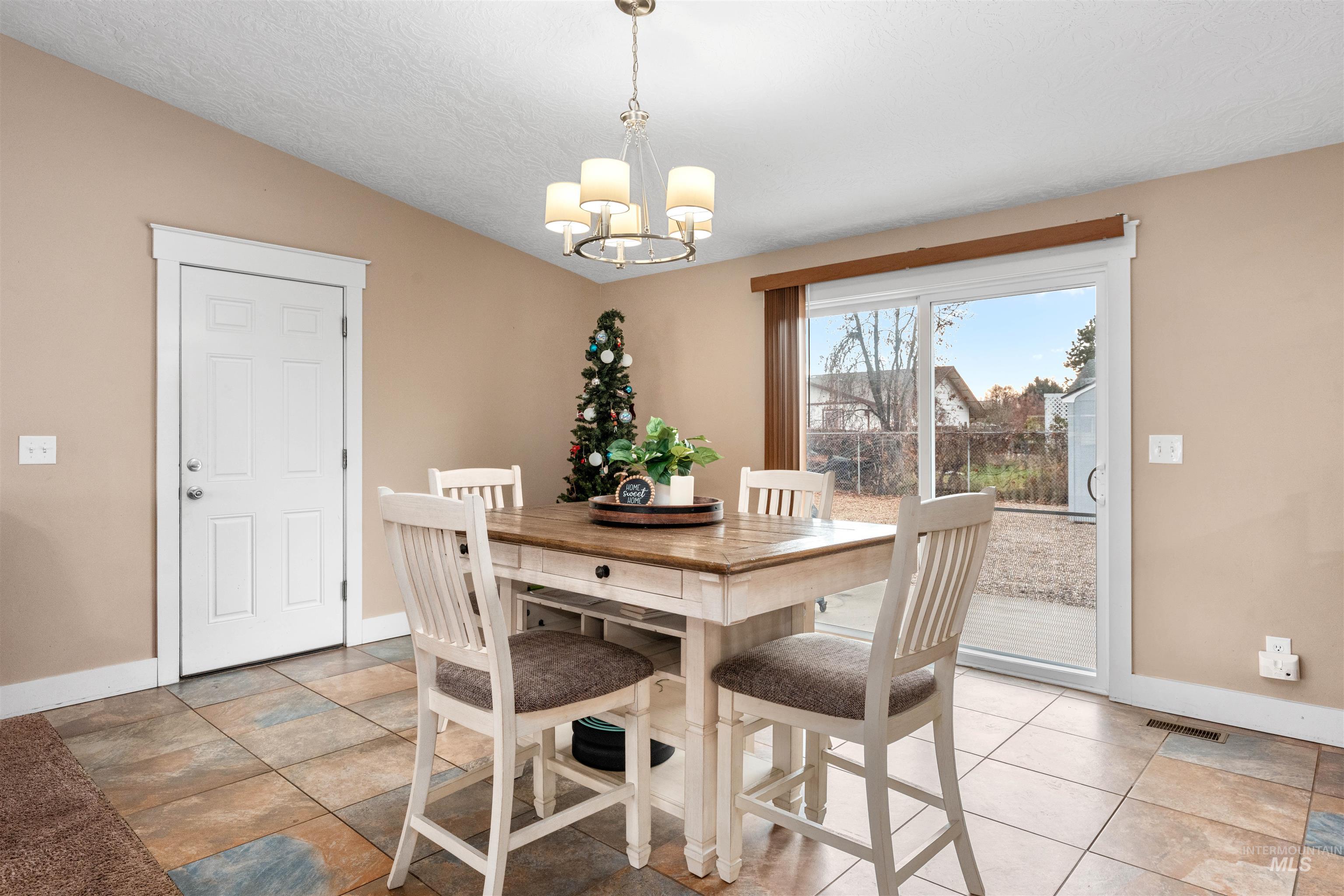 Dining room featuring a chandelier, a textured ceiling, and vaulted ceiling