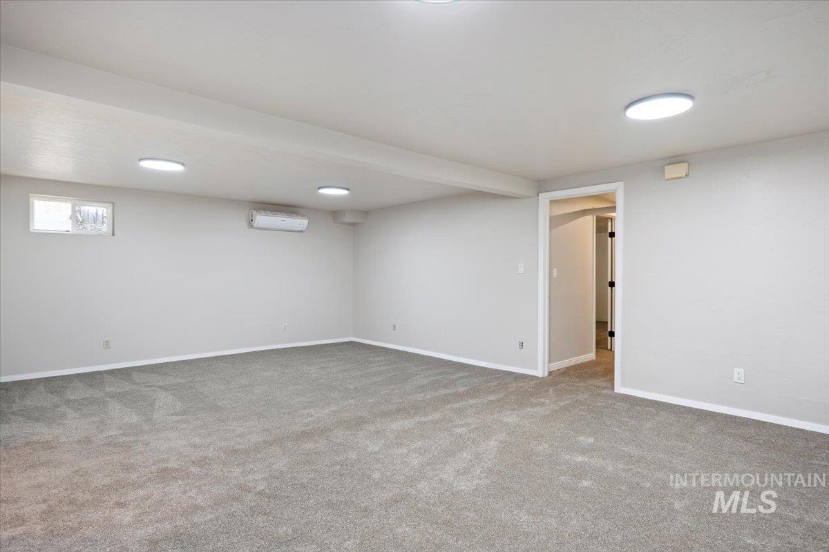 Below grade area with carpet and a wall mounted air conditioner