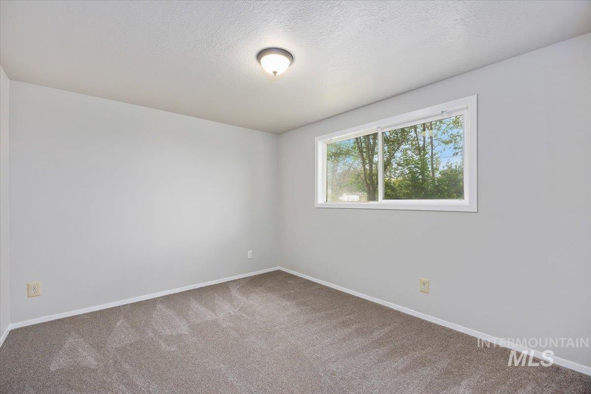 Spare room with carpet and a textured ceiling