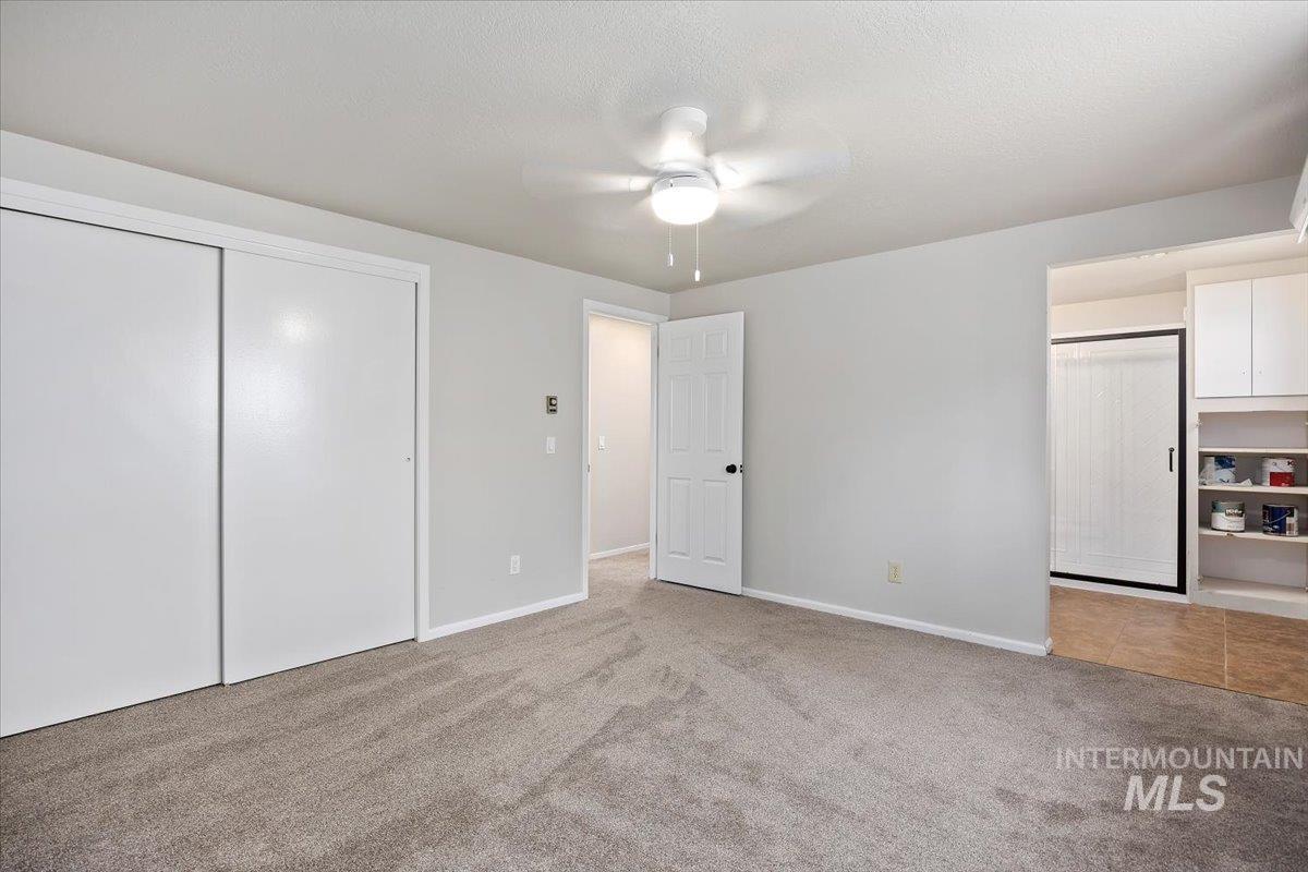 Unfurnished bedroom featuring carpet flooring, a closet, and ceiling fan