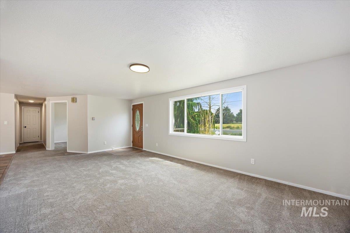Carpeted spare room featuring a textured ceiling