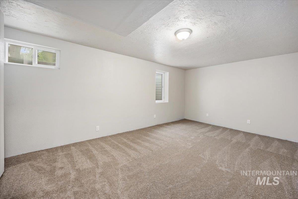 Carpeted spare room with a textured ceiling