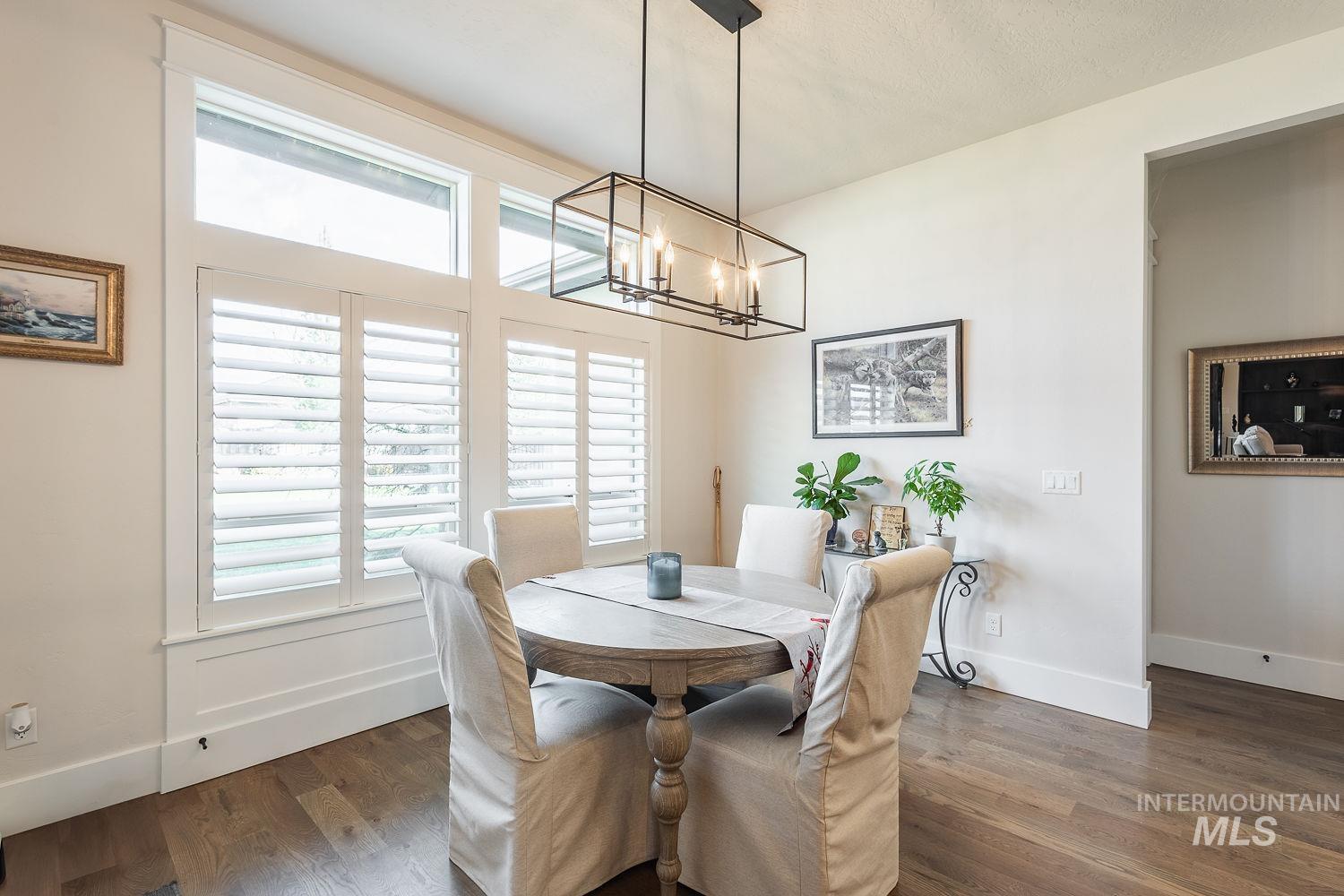 Dining room with dark wood-style floors and a chandelier