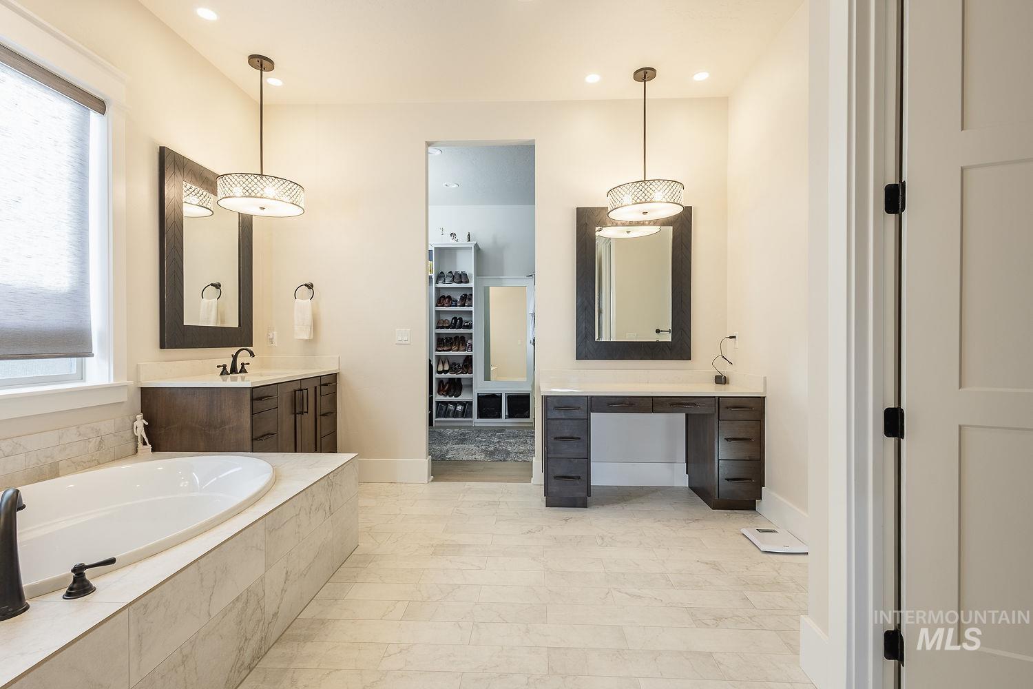 Full bath featuring vanity, a garden tub, recessed lighting, and a spacious closet