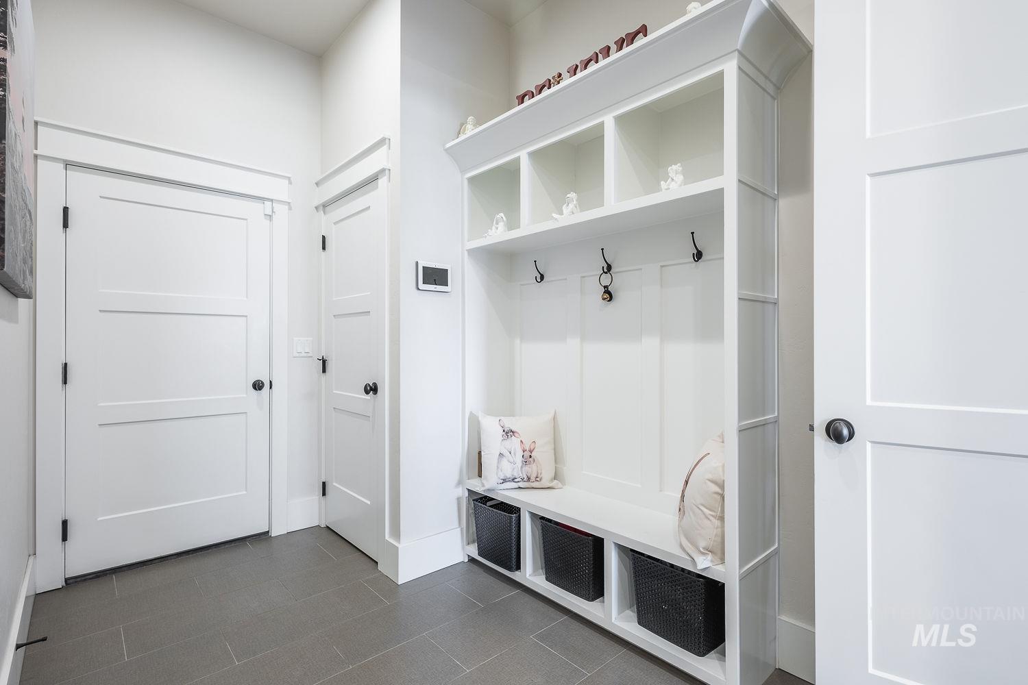 Mudroom with dark tile patterned floors