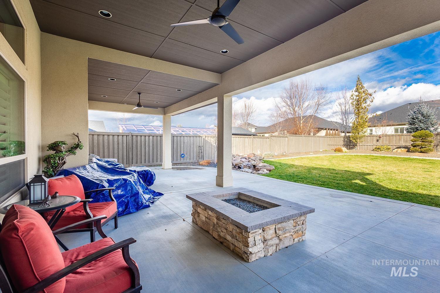 Fenced backyard with a patio area and a ceiling fan