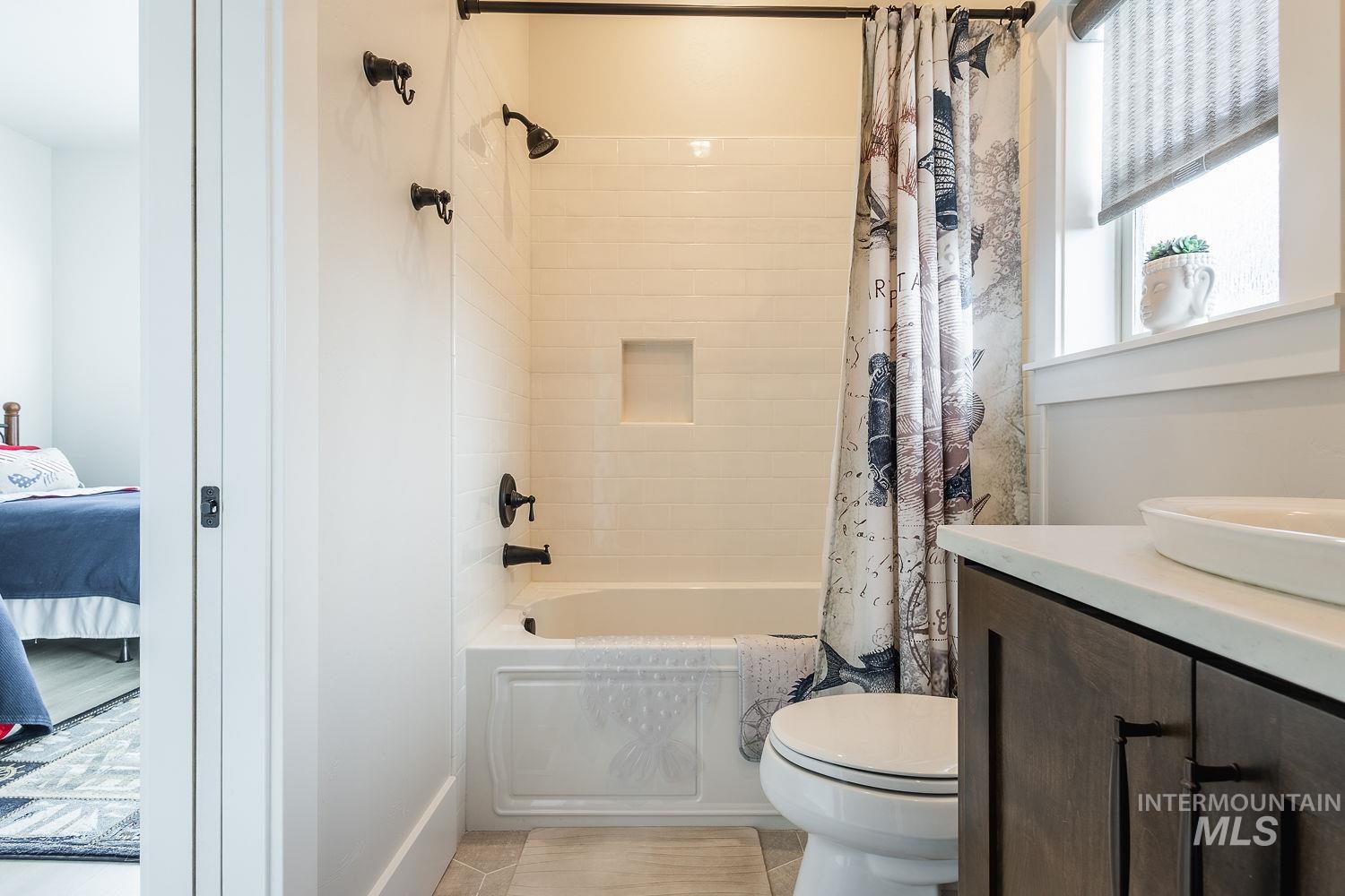 Ensuite bathroom with shower / tub combo and vanity