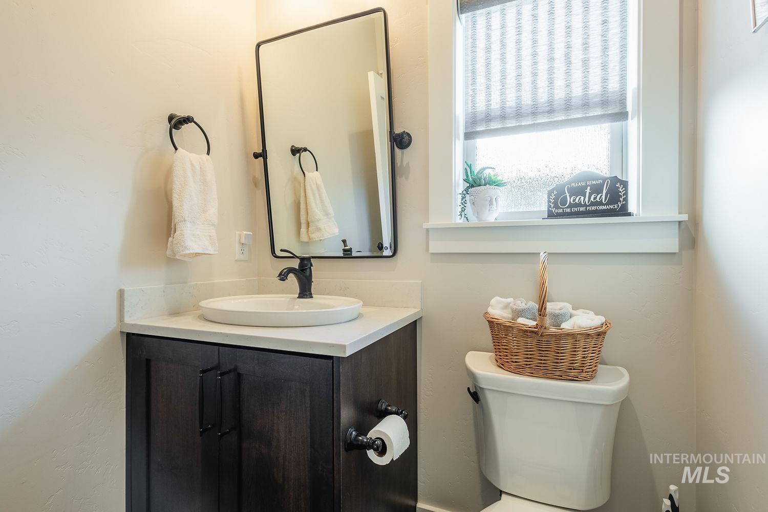 Half bathroom with vanity and toilet