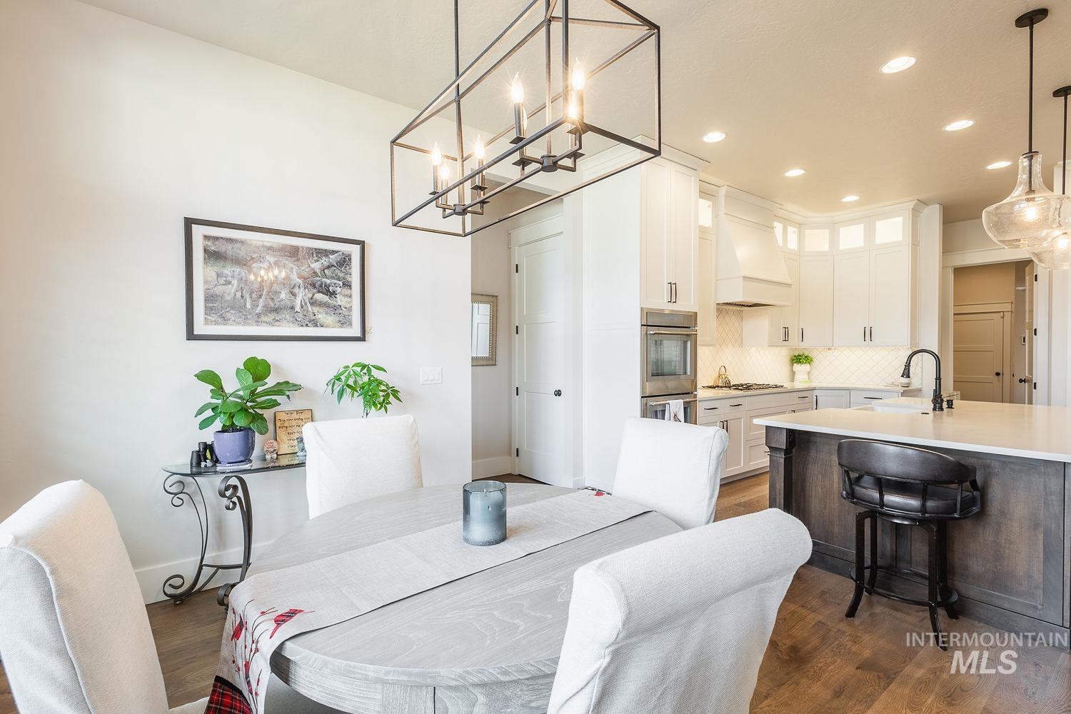Dining space featuring dark wood-style flooring, a chandelier, and recessed lighting
