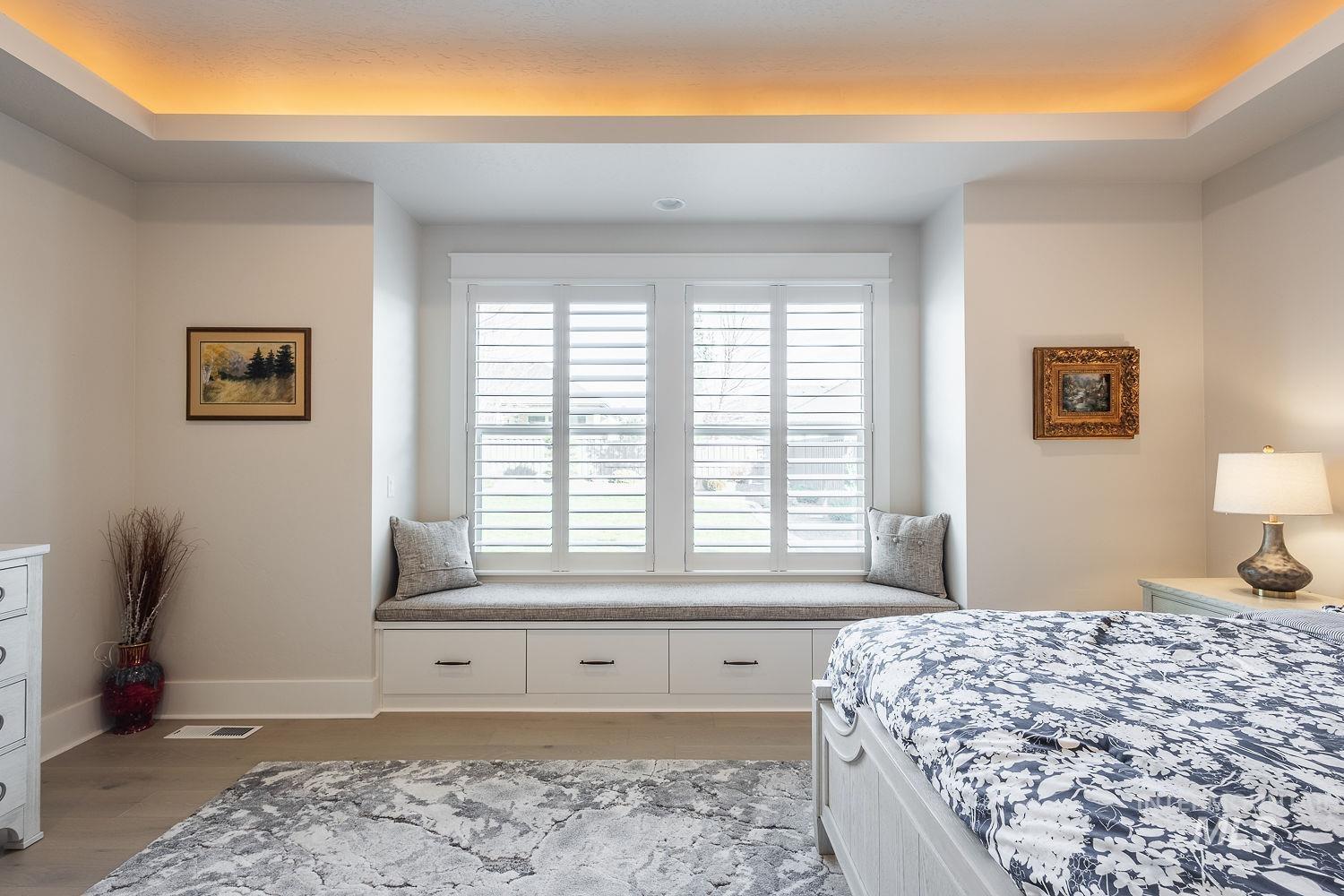 Bedroom with a tray ceiling and light wood-style flooring