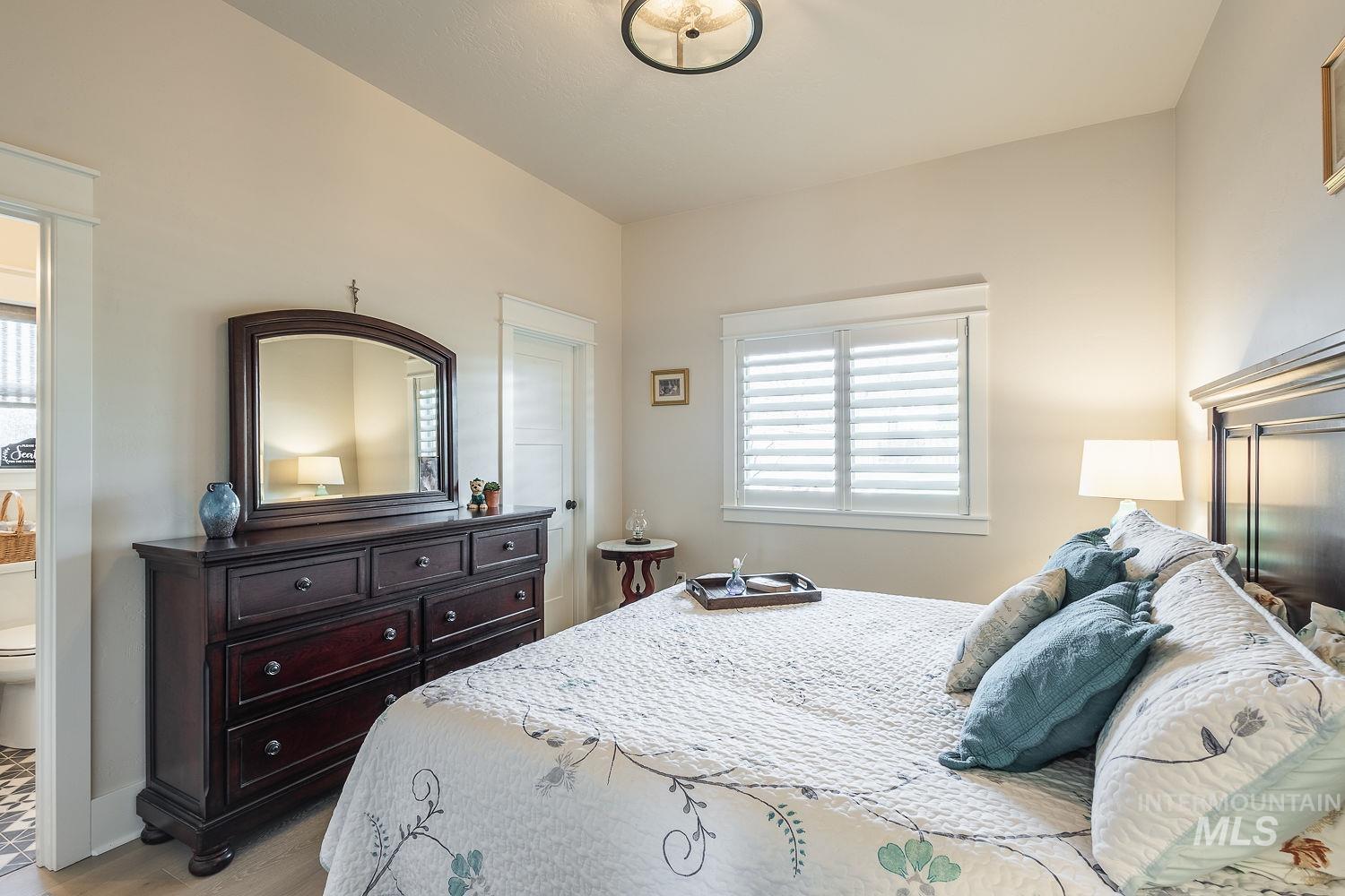 Bedroom with multiple windows and light wood finished floors