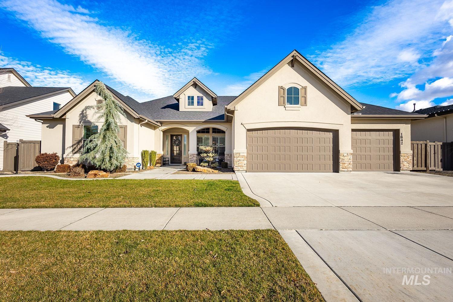 View of front of property with stone siding, stucco siding, and concrete driveway