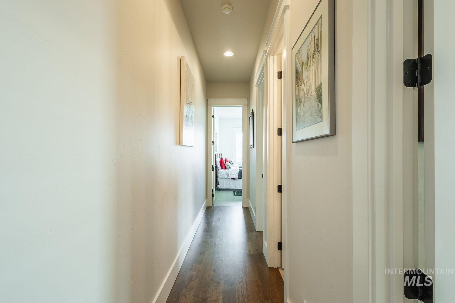 Corridor with dark wood-type flooring and recessed lighting