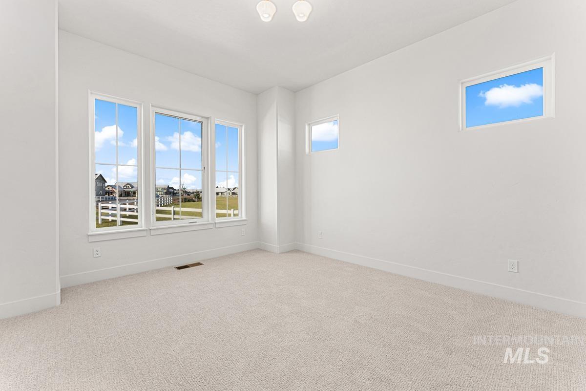 Spare room with light colored carpet and baseboards