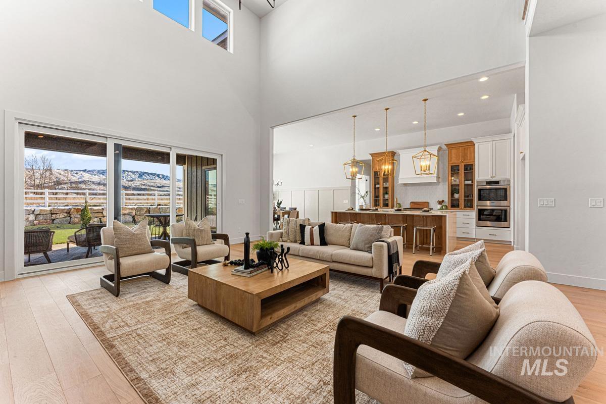 Living room featuring light wood-style floors, a mountain view, plenty of natural light, a high ceiling, and recessed lighting