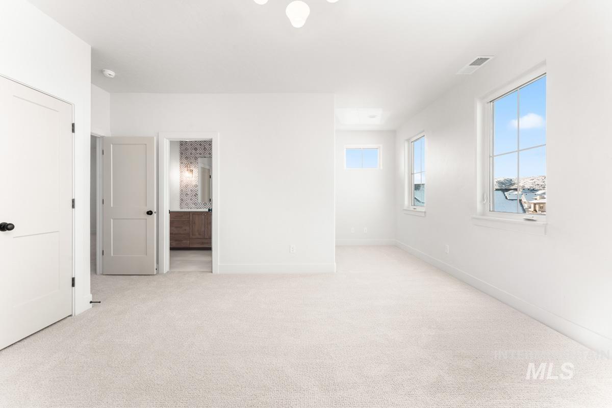 Empty room featuring light carpet and baseboards