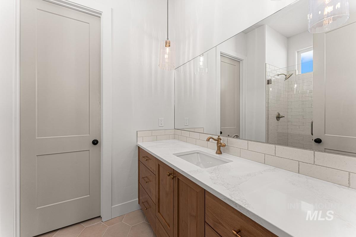 Full bathroom with light tile patterned flooring, vanity, and a shower stall