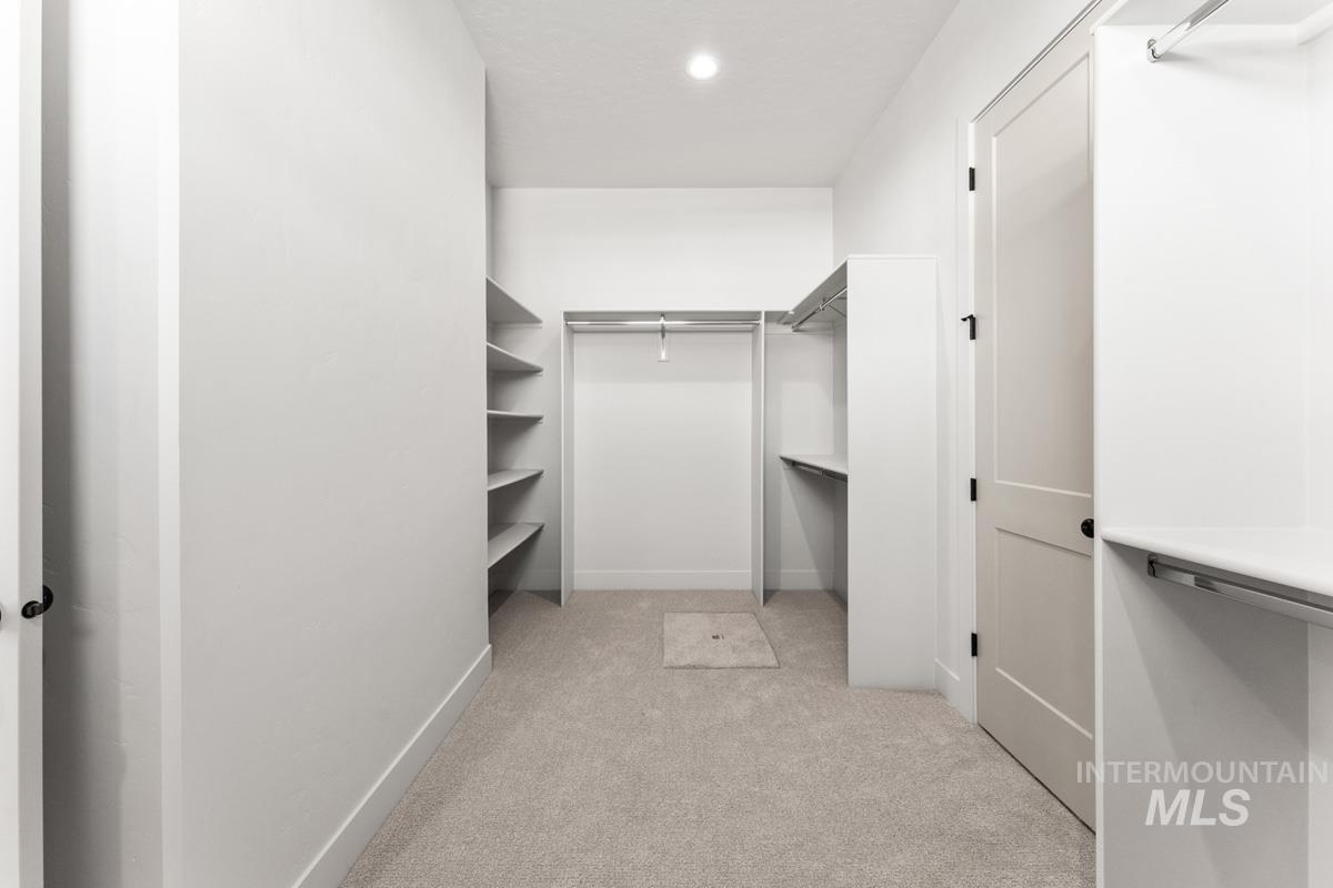 Walk in closet with light carpet