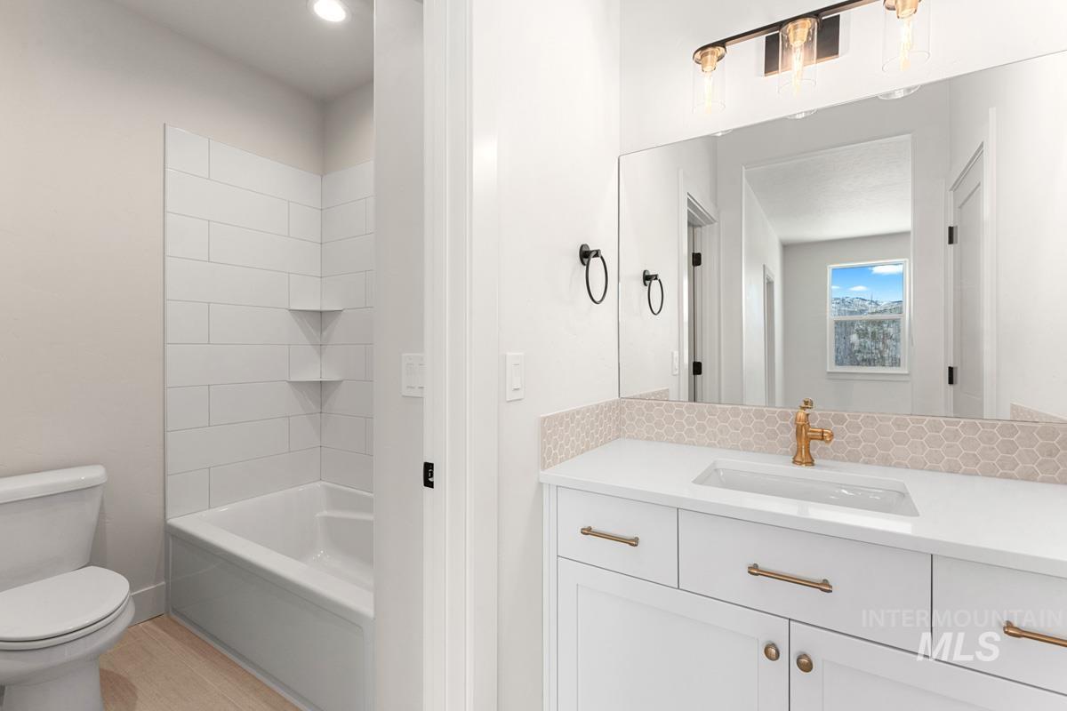Bathroom with vanity, light wood-style flooring, and bathing tub / shower combination