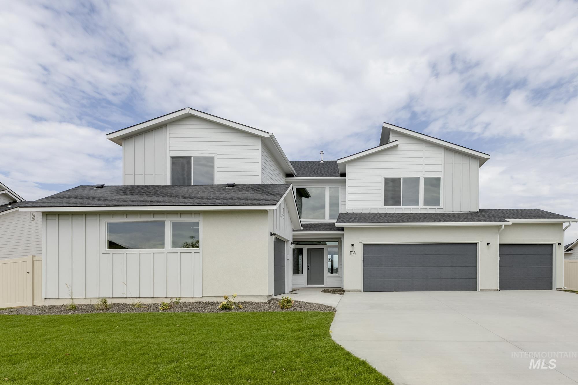View of front of home featuring board and batten siding, a shingled roof, a garage, and driveway