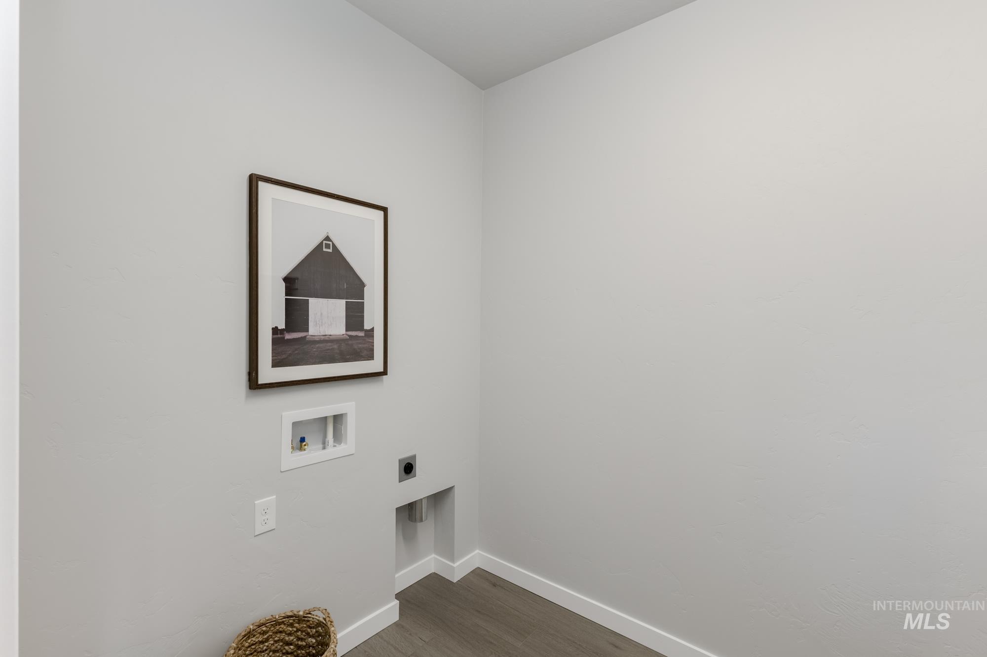 Washroom featuring dark wood finished floors, hookup for an electric dryer, and washer hookup