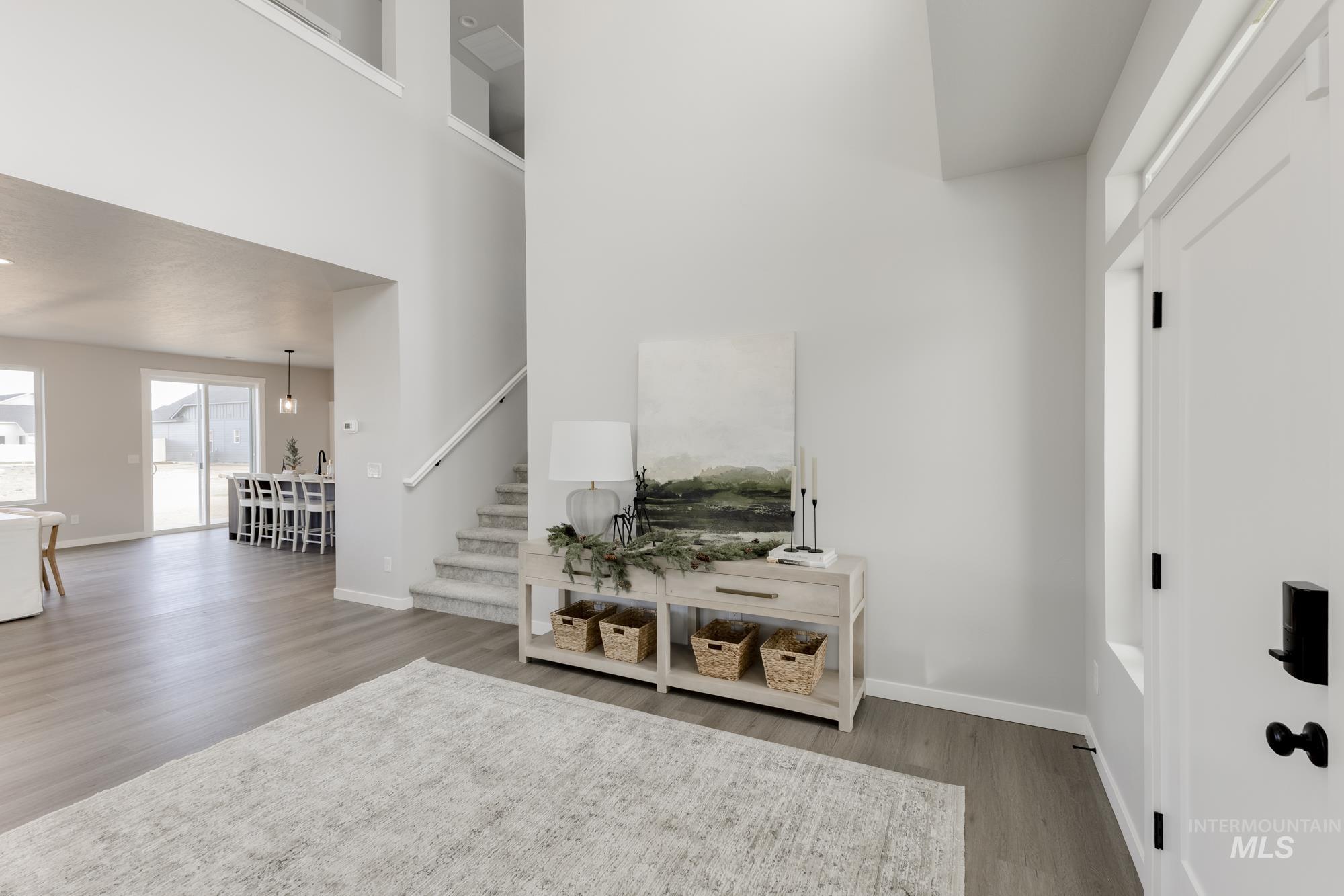 Living area with wood finished floors, stairway, and a high ceiling