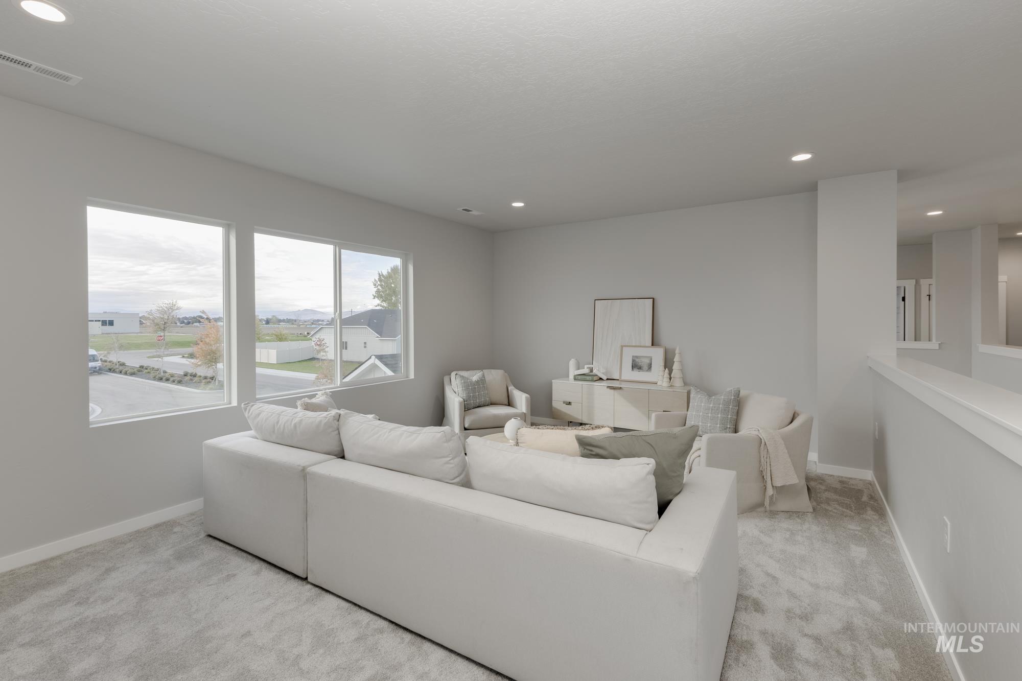 Living room with recessed lighting and light colored carpet