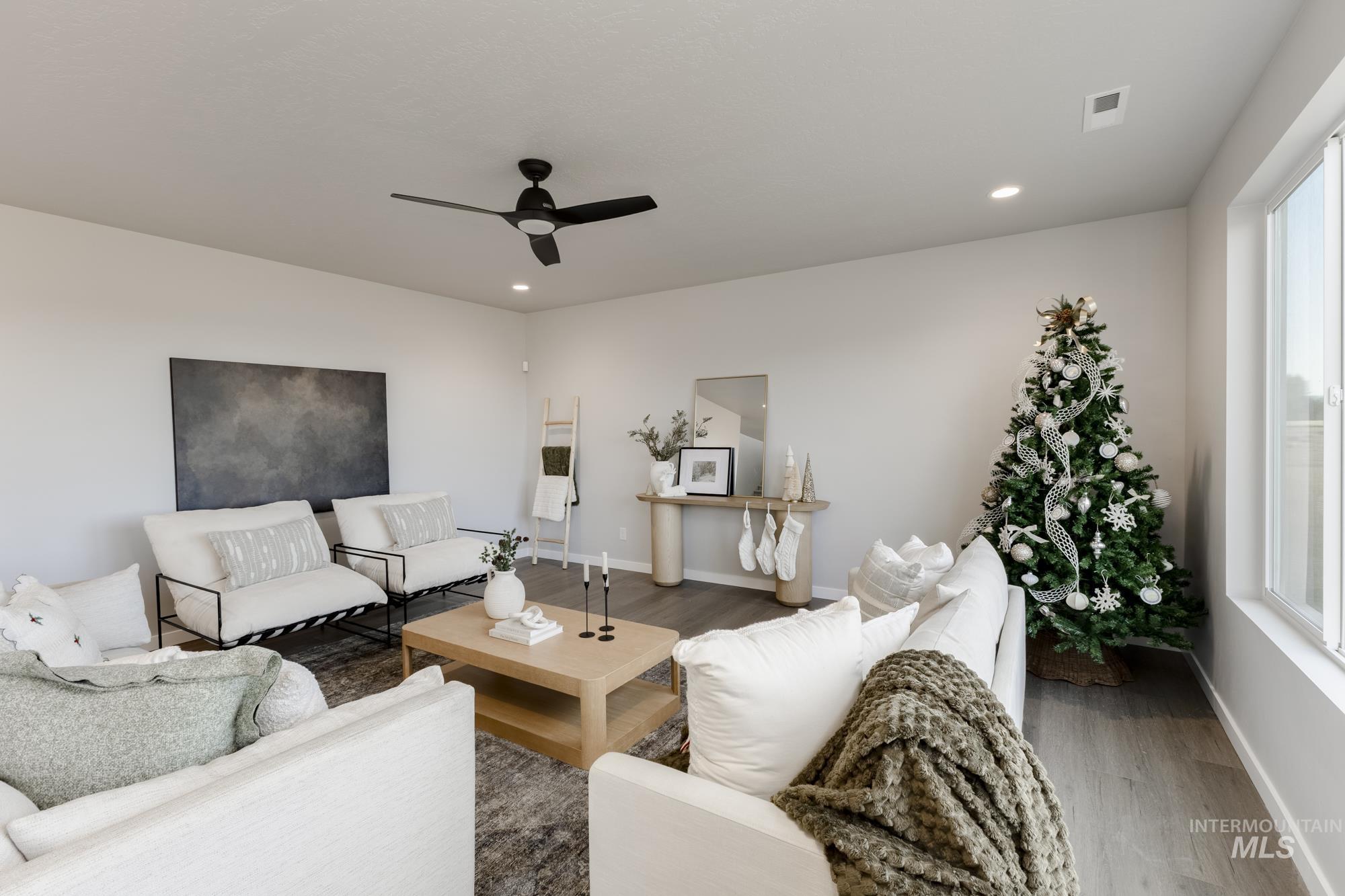 Living area with wood finished floors, ceiling fan, and recessed lighting