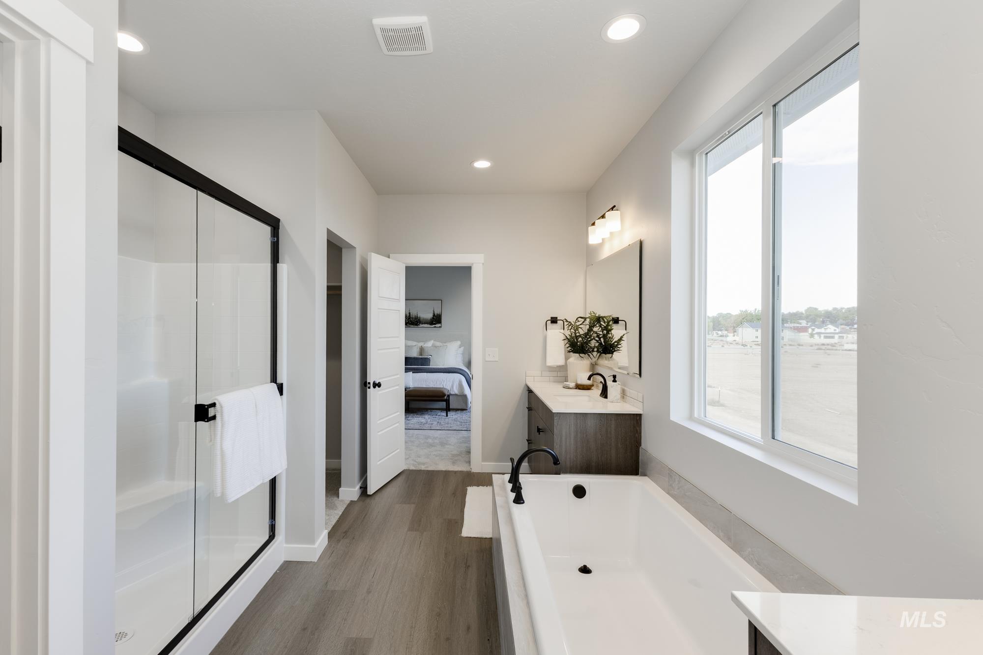 Bathroom with vanity, a freestanding tub, dark wood-type flooring, recessed lighting, and ensuite bathroom