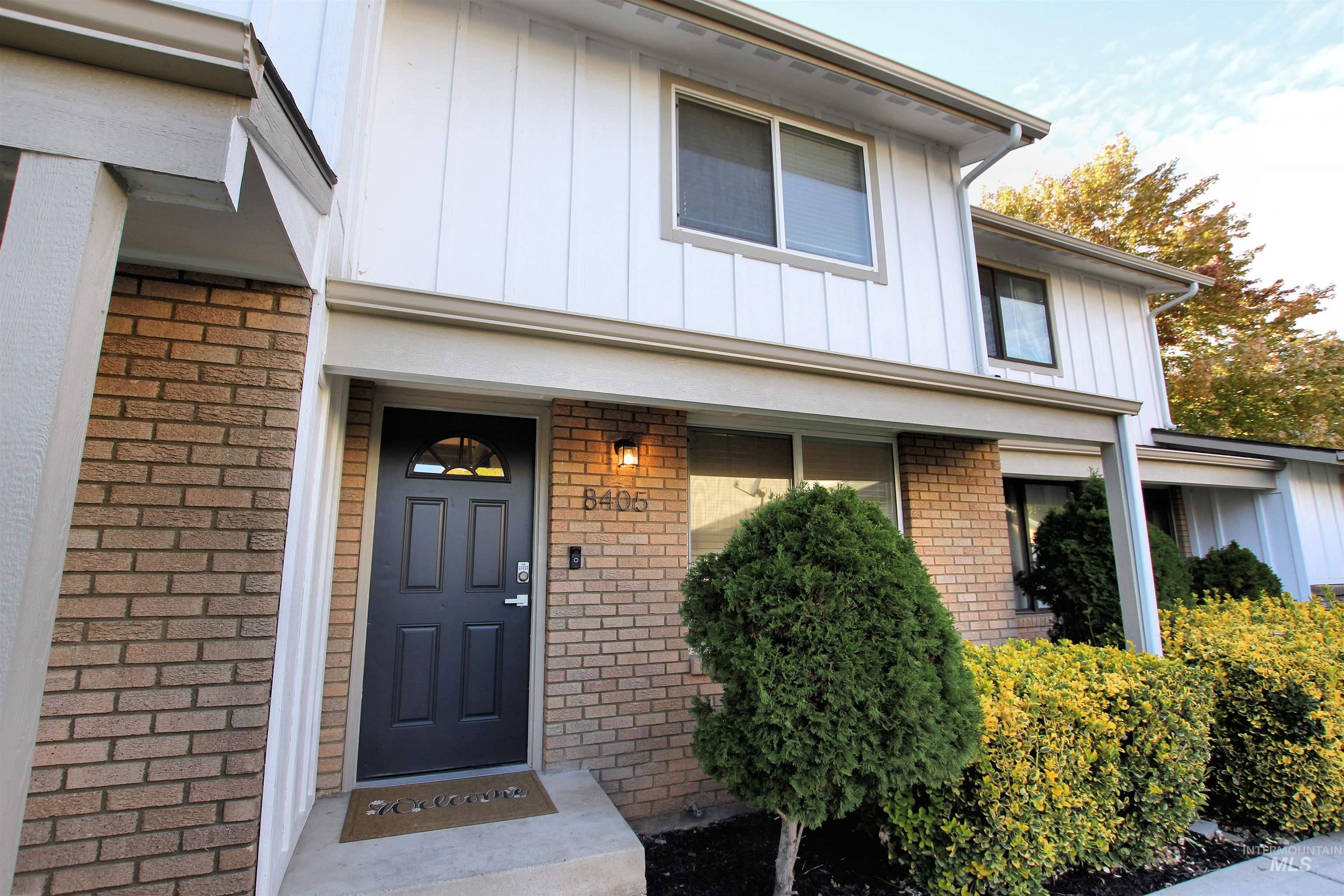 View of exterior entry featuring board and batten siding and brick siding