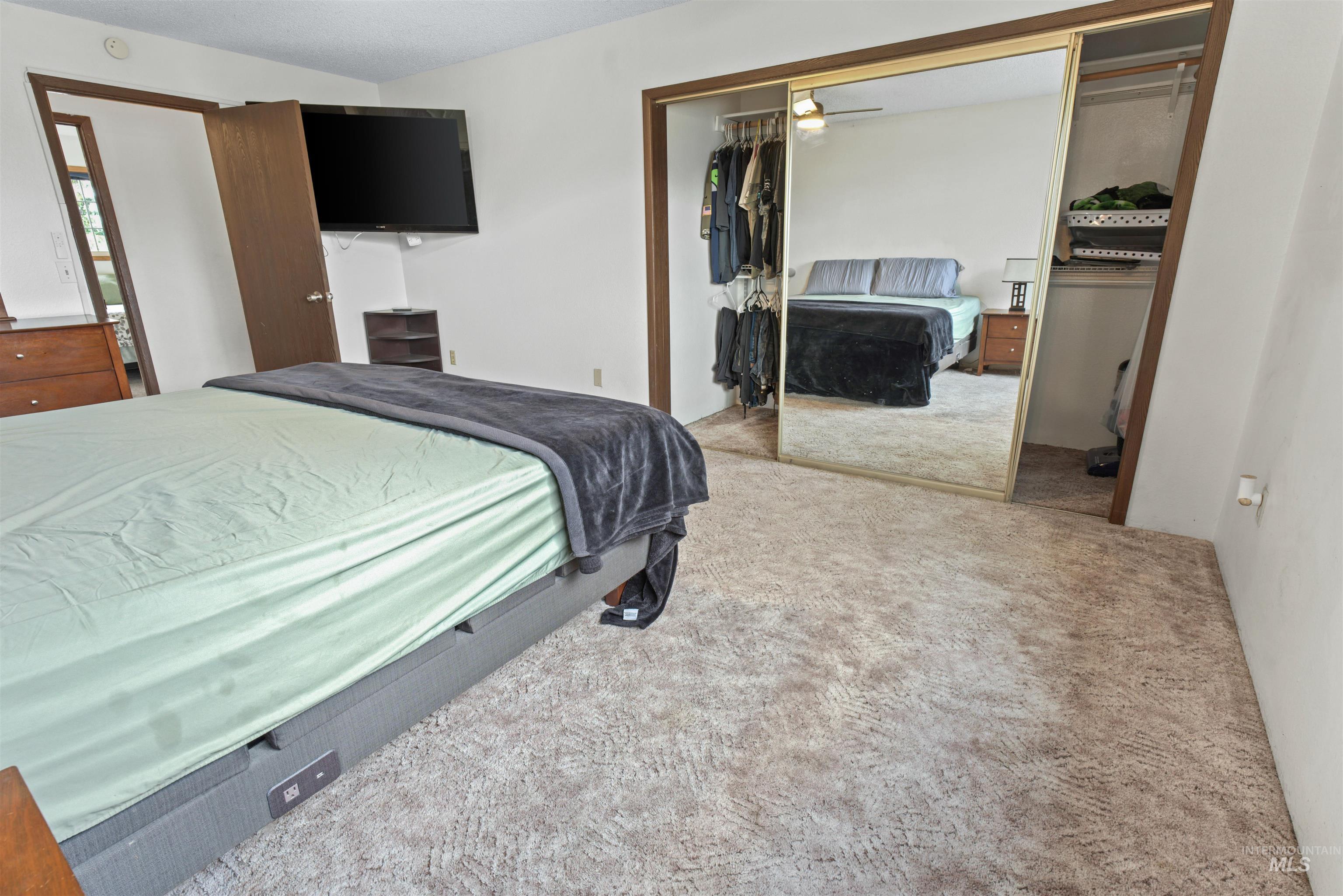 Spacious room with light-toned carpeting and white walls