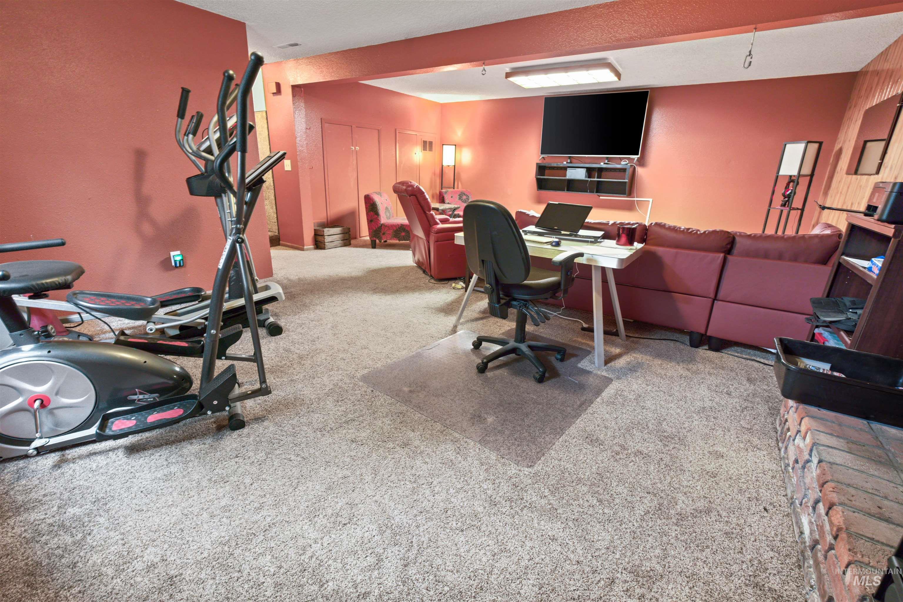 Carpeted room with a partial brick fireplace hearth
