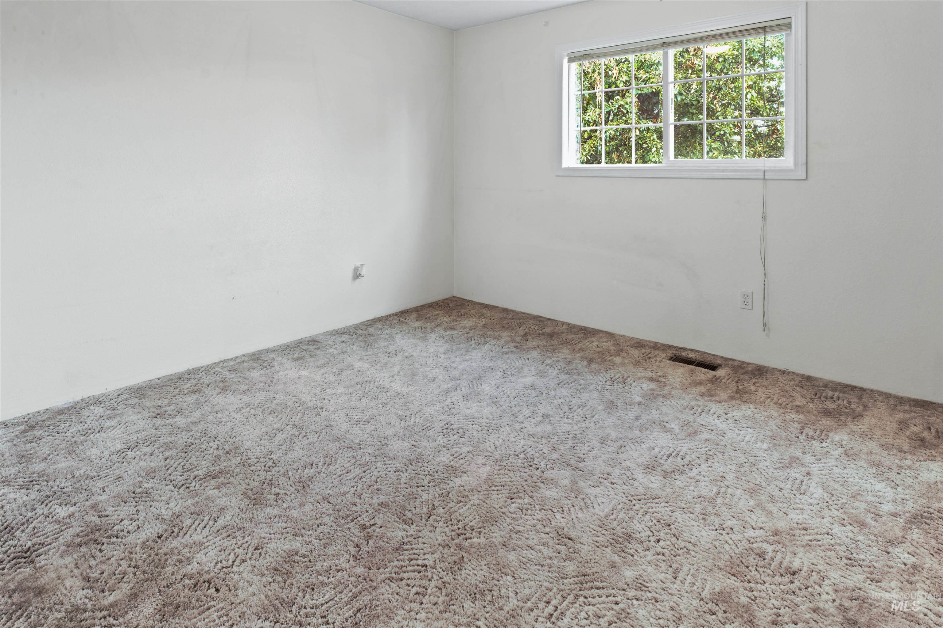 Neutral wall finishes complement the patterned carpet flooring