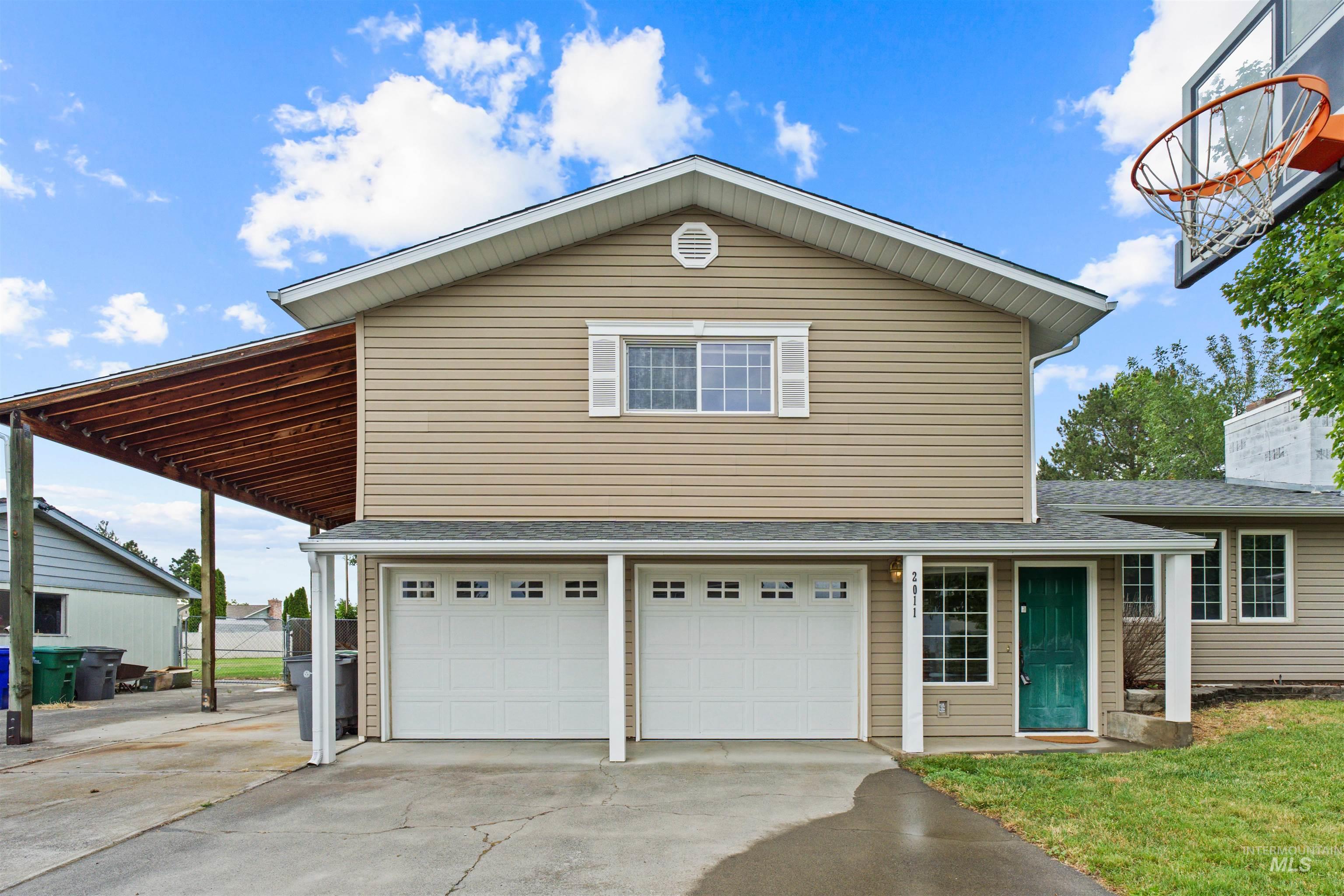 Two-story residence featuring tan siding and white trim