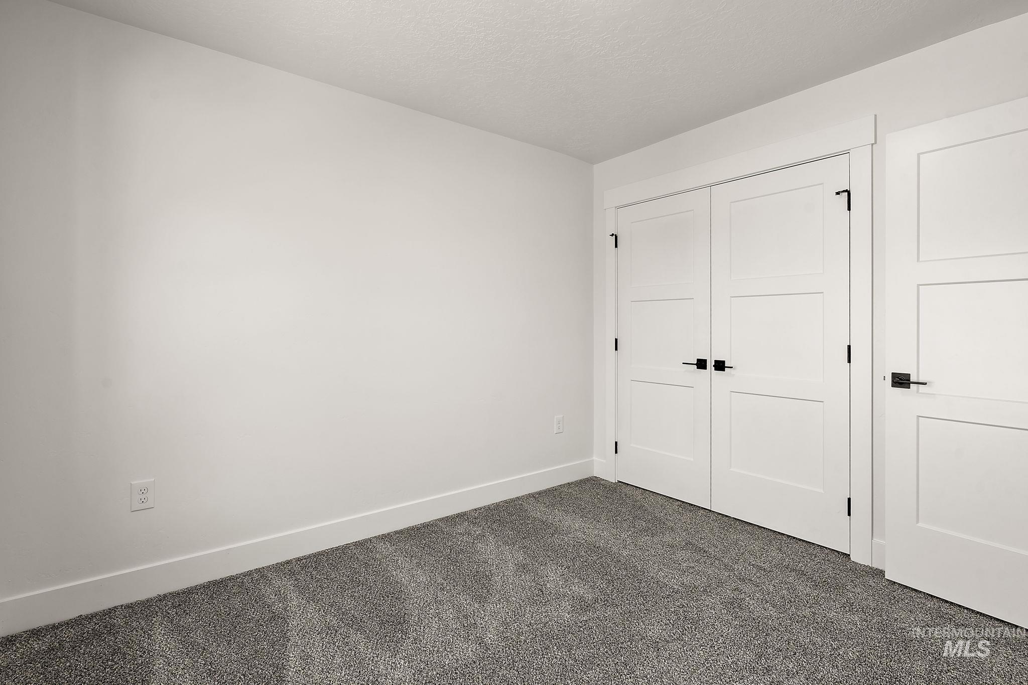 Unfurnished bedroom with dark colored carpet and a closet