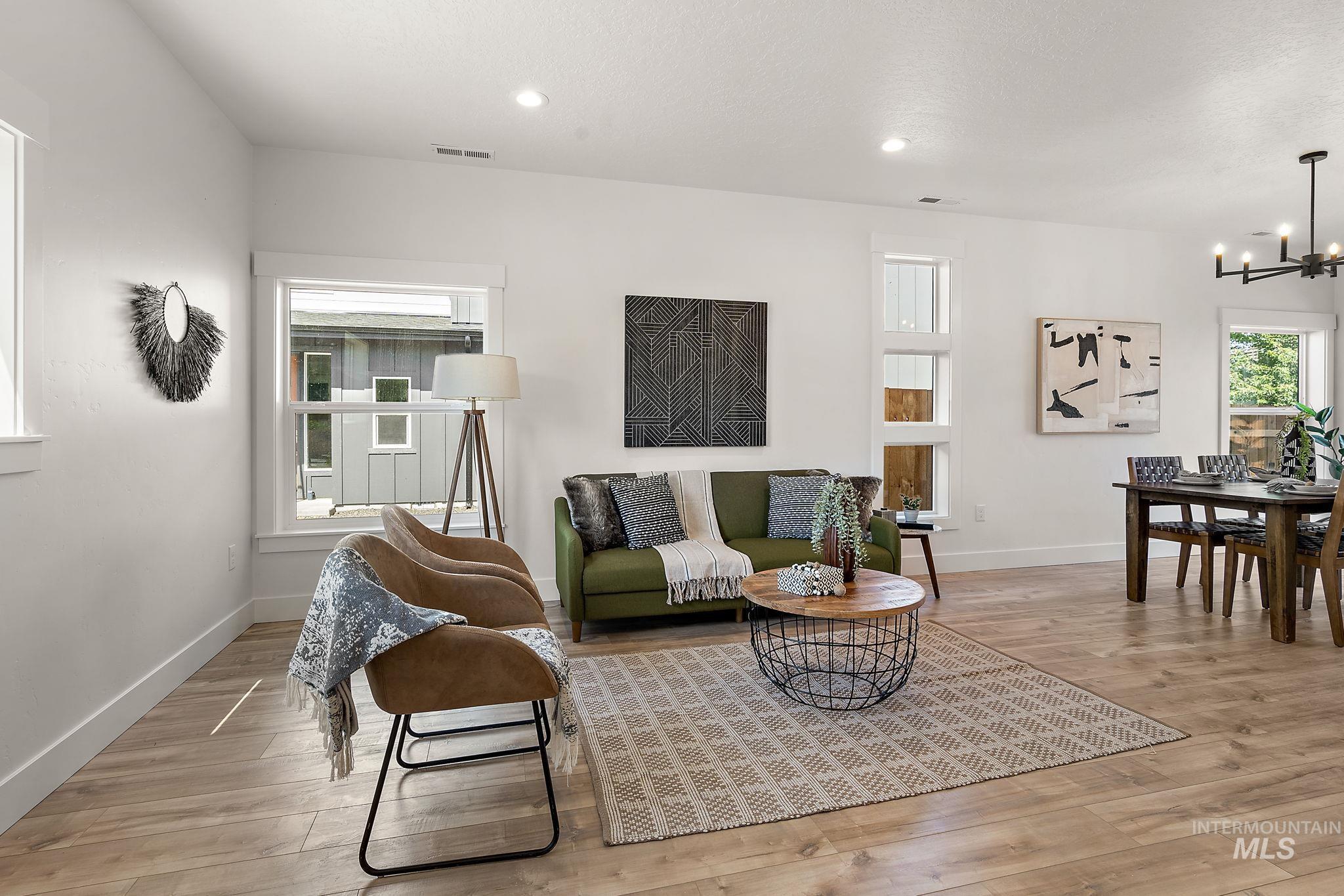 Living area with a chandelier, light wood-type flooring, and recessed lighting