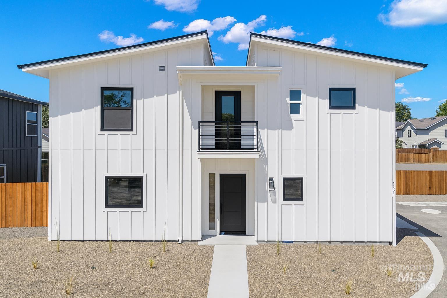 View of front of property featuring board and batten siding and a balcony