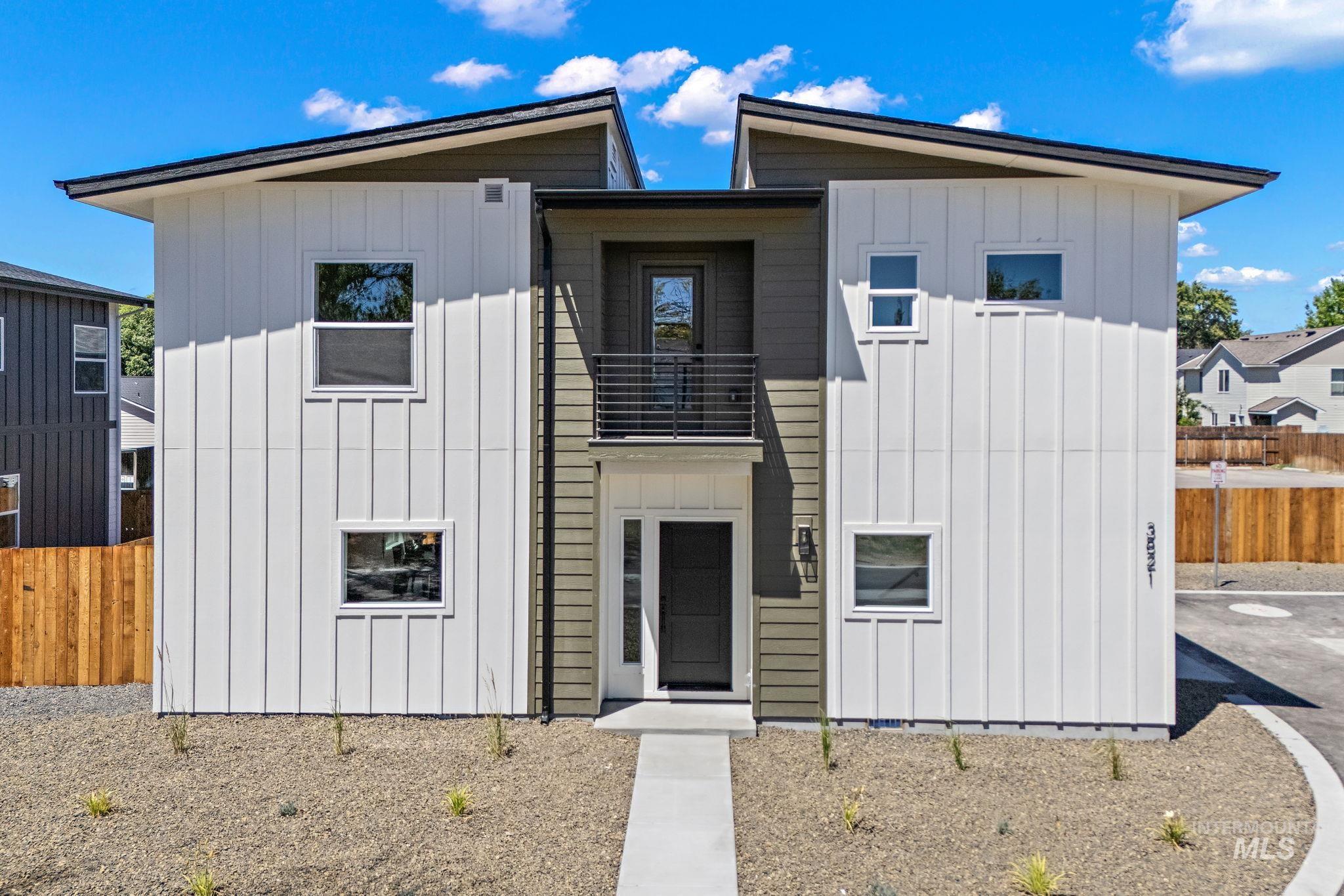View of front facade featuring board and batten siding and a balcony