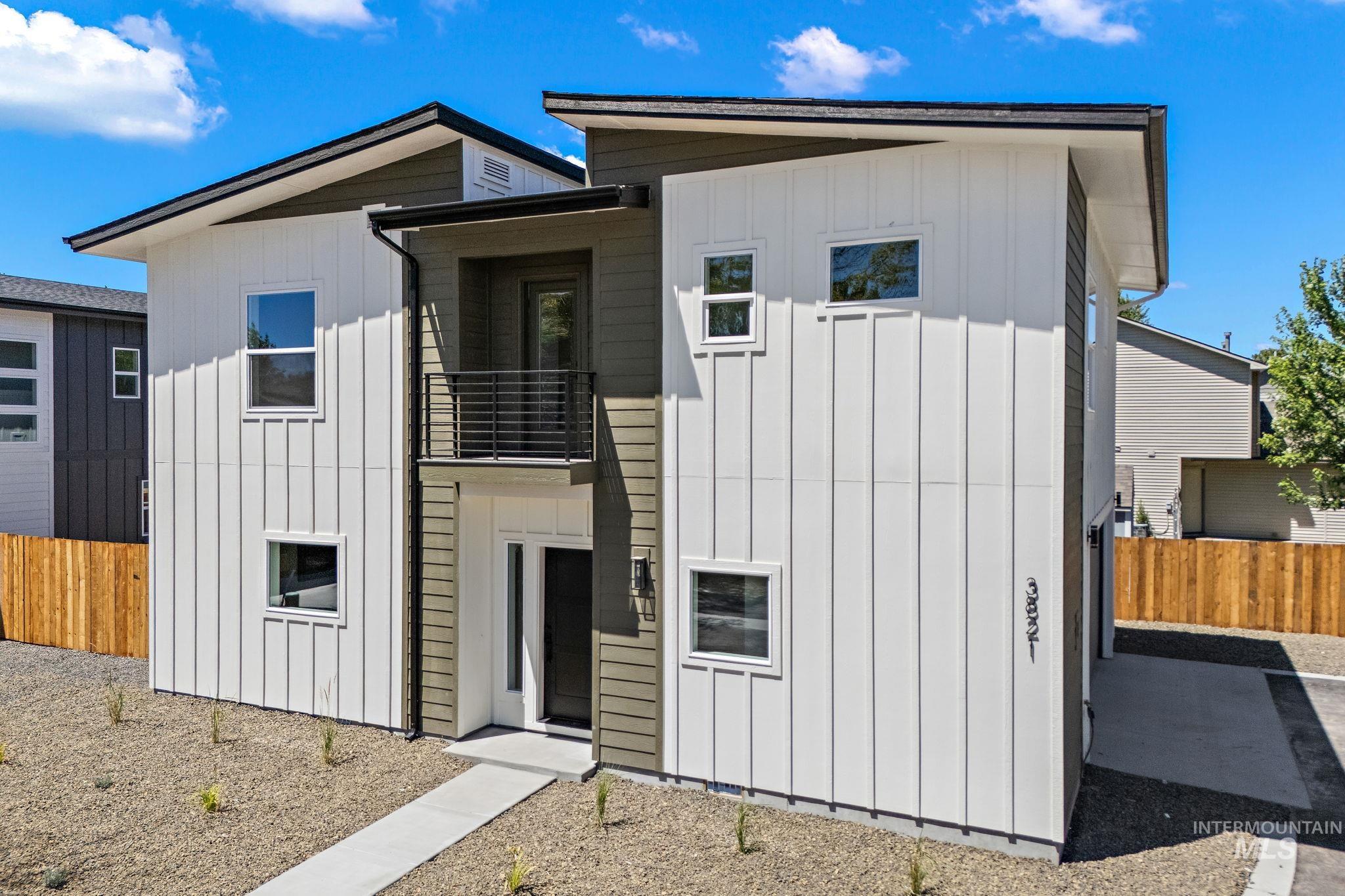 View of front of home with board and batten siding and a balcony