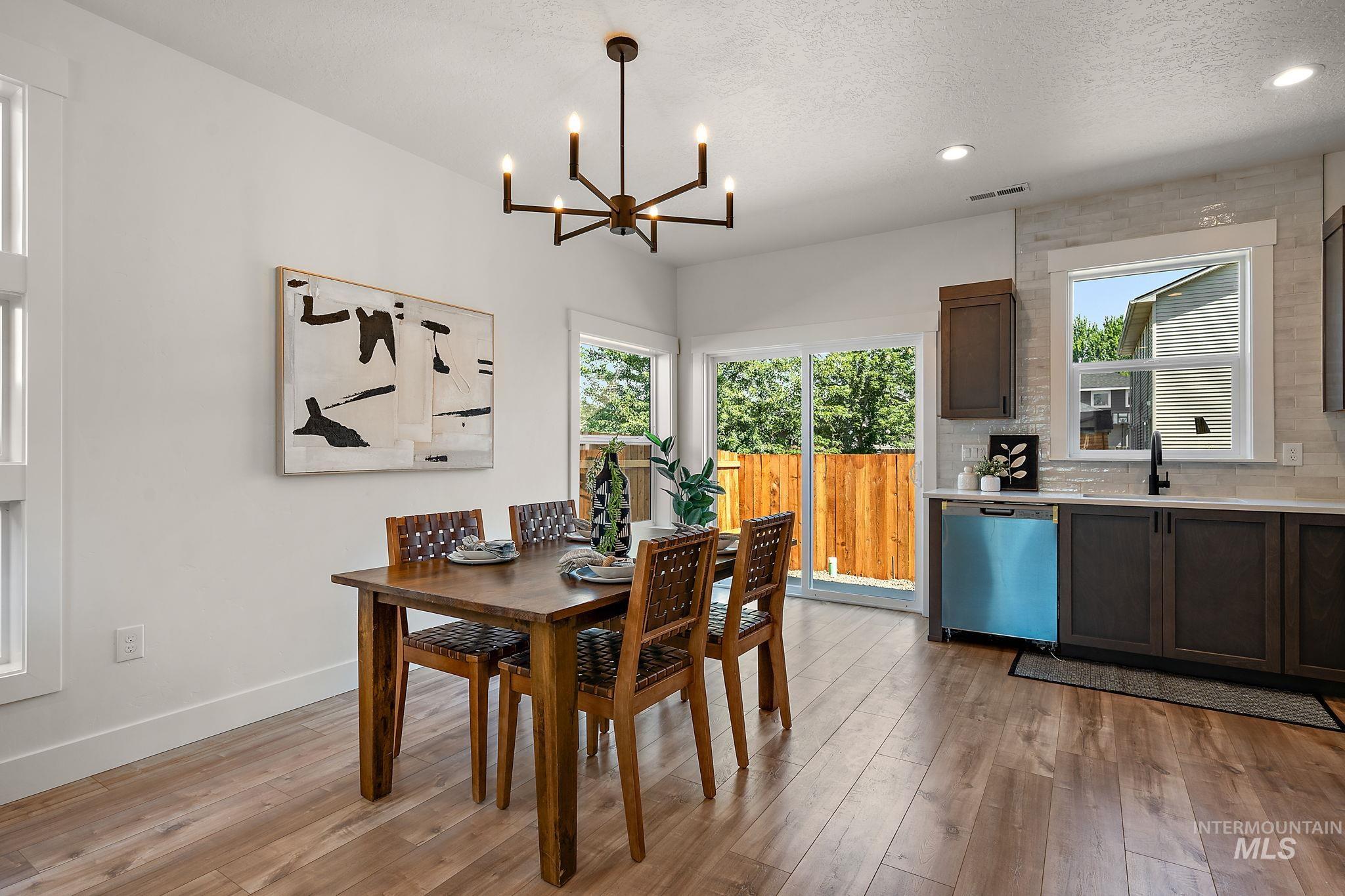 Dining area featuring a chandelier, light wood-style flooring, recessed lighting, and a textured ceiling