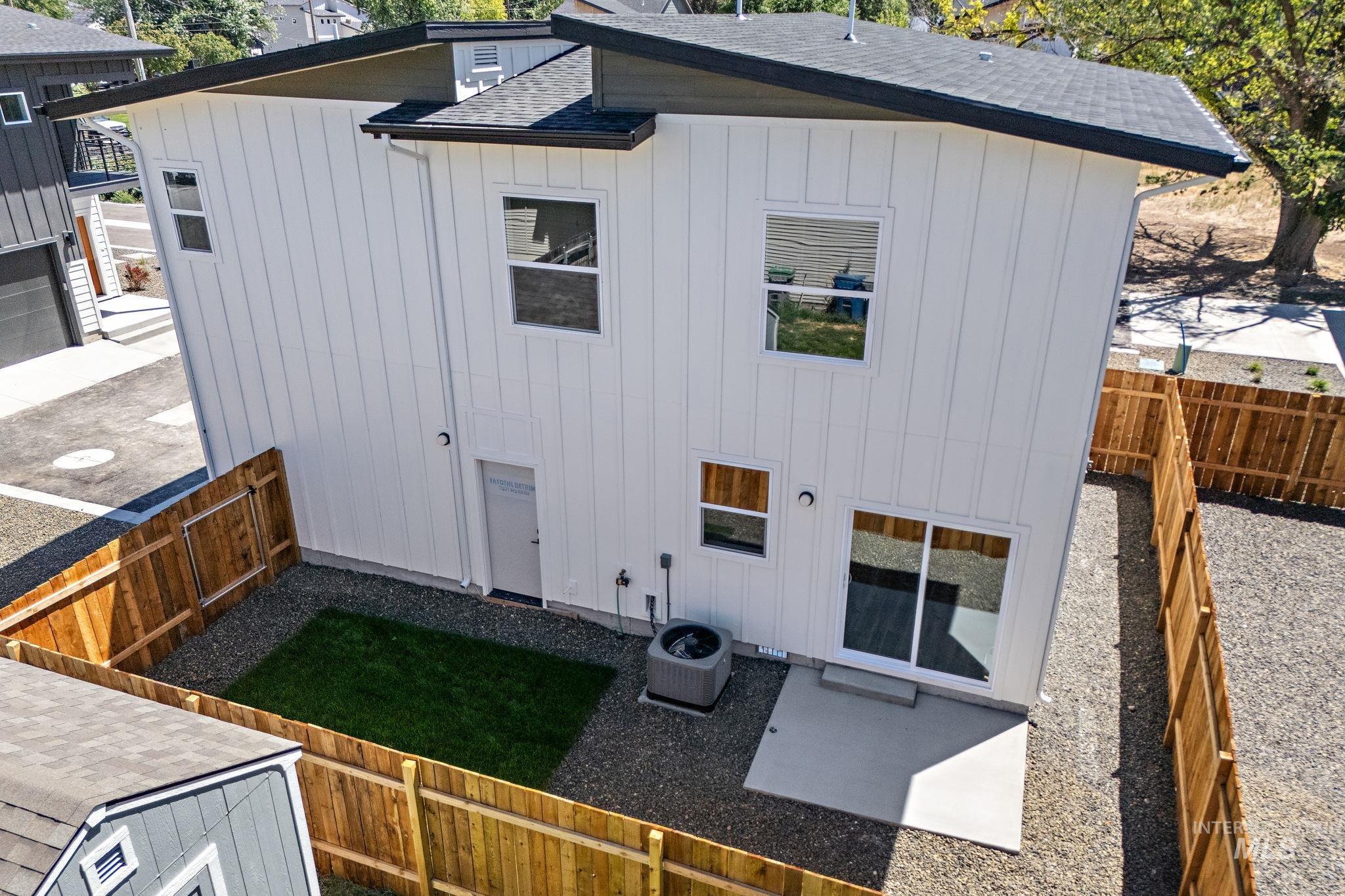 Back of property featuring a shingled roof, a fenced backyard, and board and batten siding