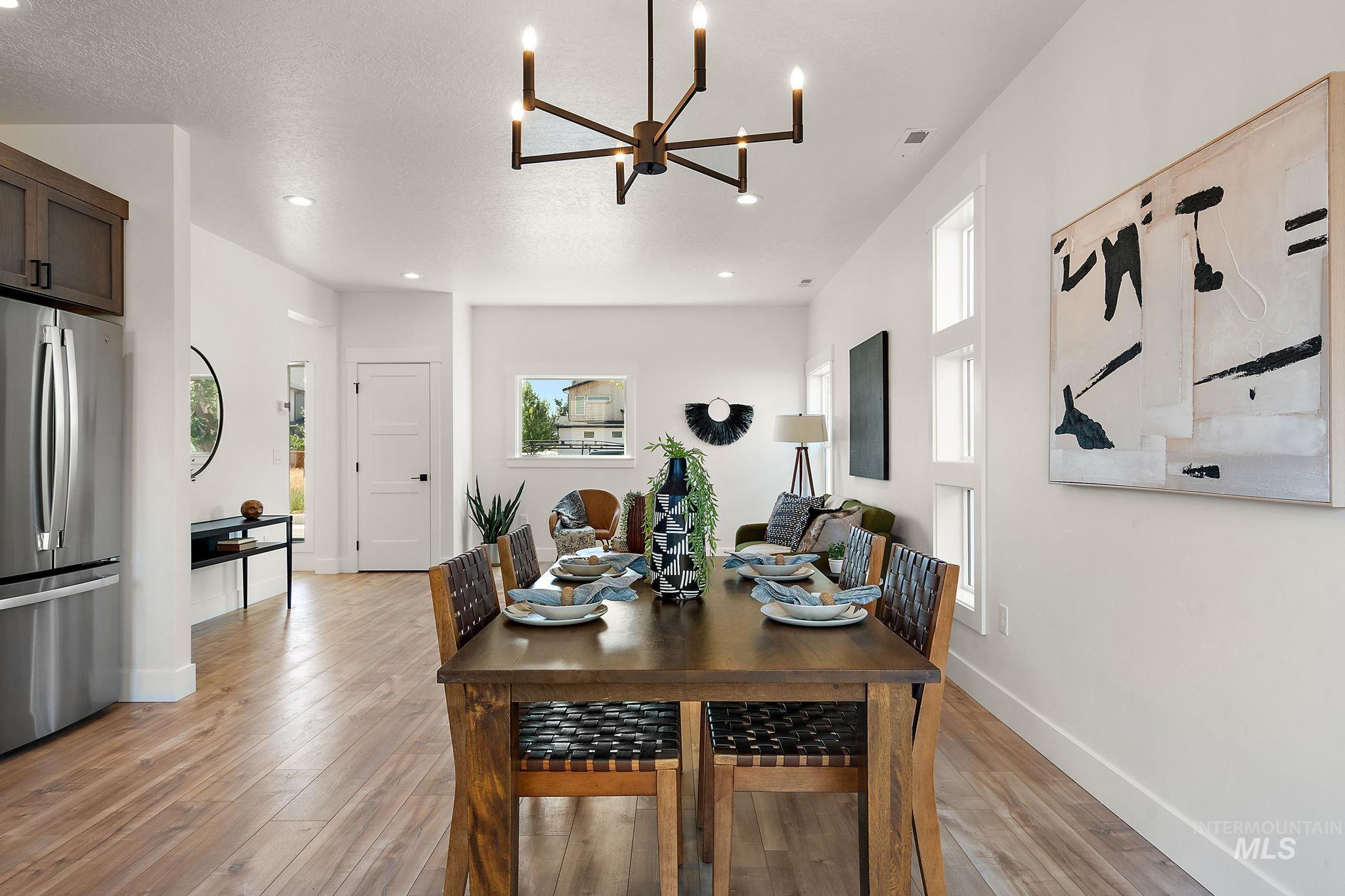 Dining room featuring light wood-style flooring, a chandelier, and recessed lighting