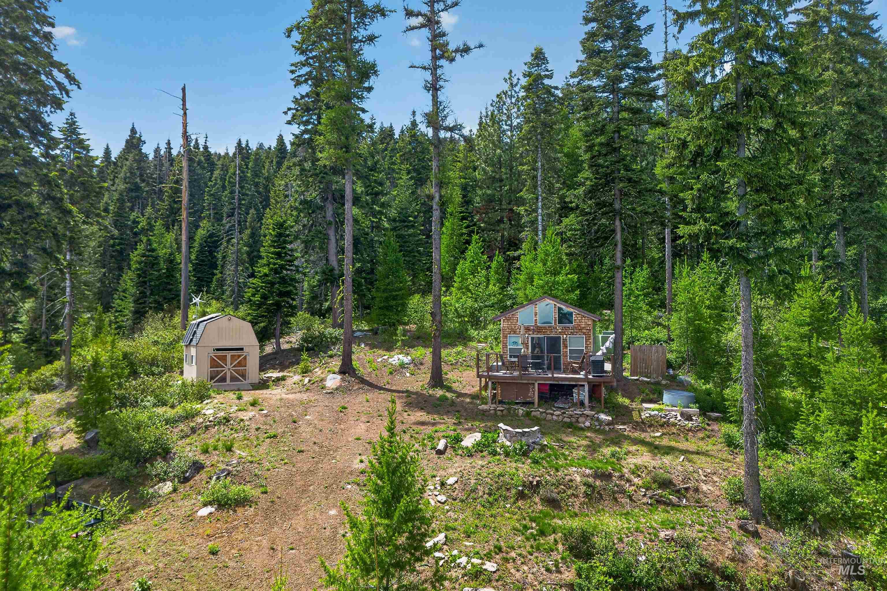 Wood-sided cabin featuring a multi-level deck and prominent window array